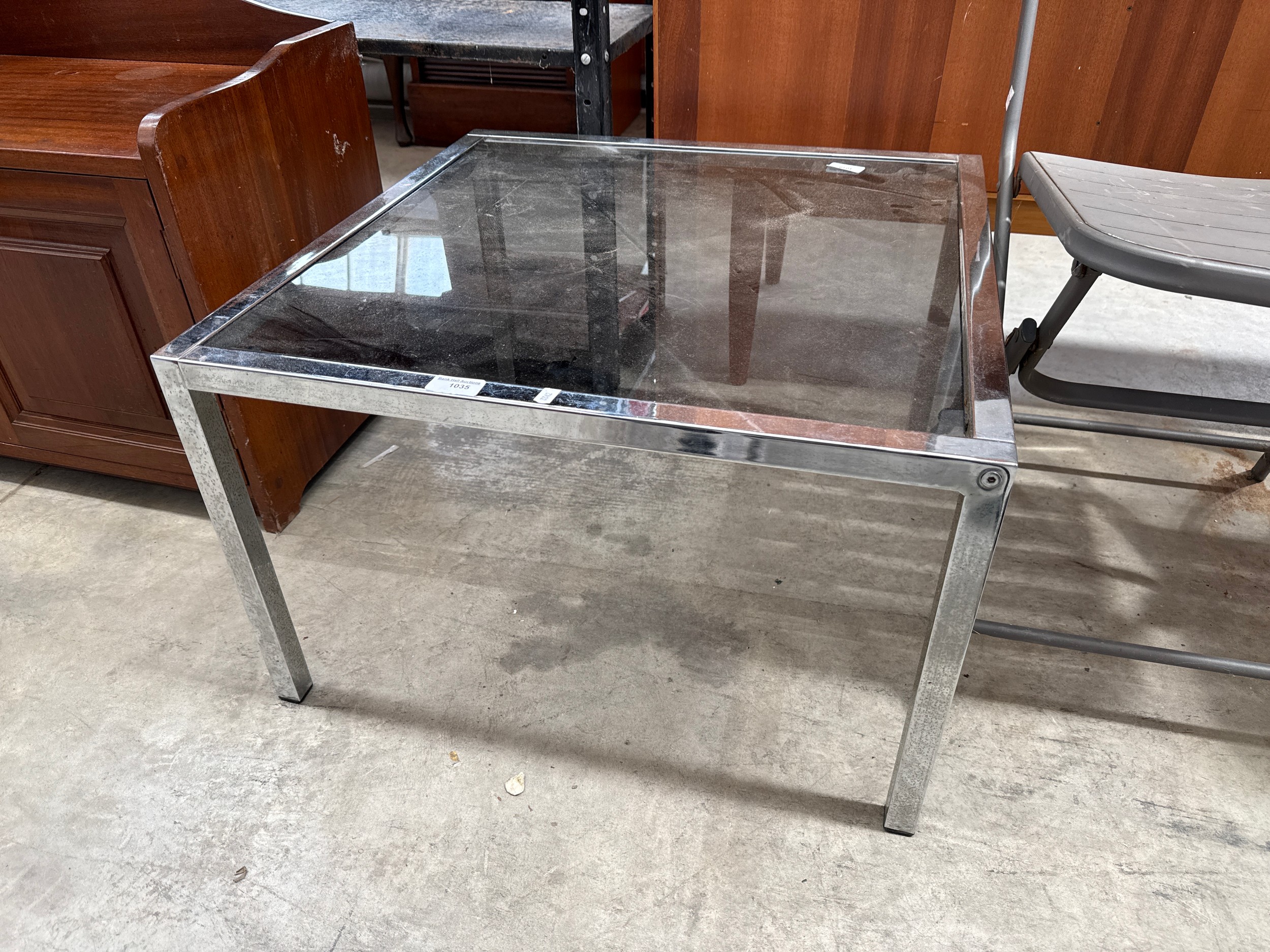 A square chromed frame side table with smoked glass top