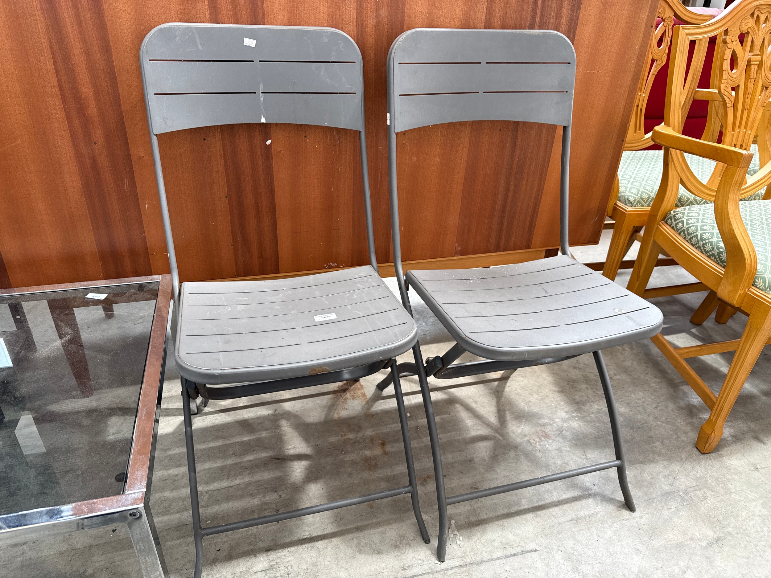 A pair of small metal folding garden chairs