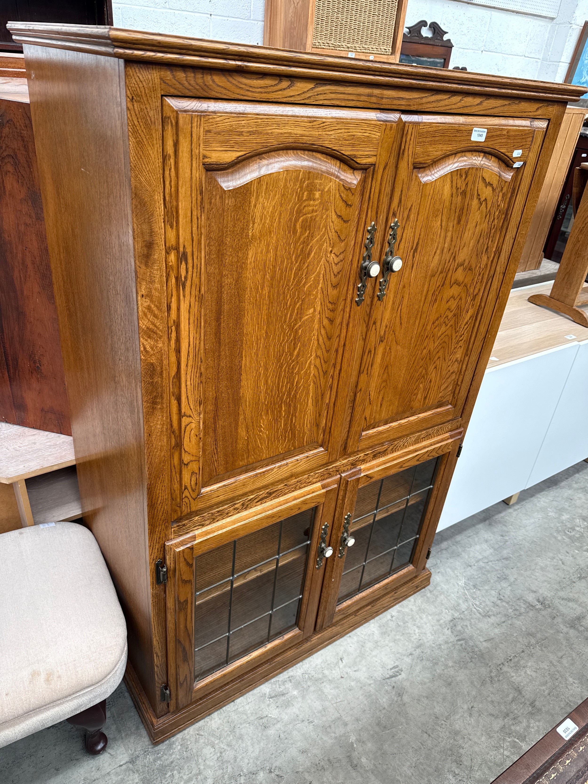 A large vintage oak cocktail cabinet with lead glazed lower doors