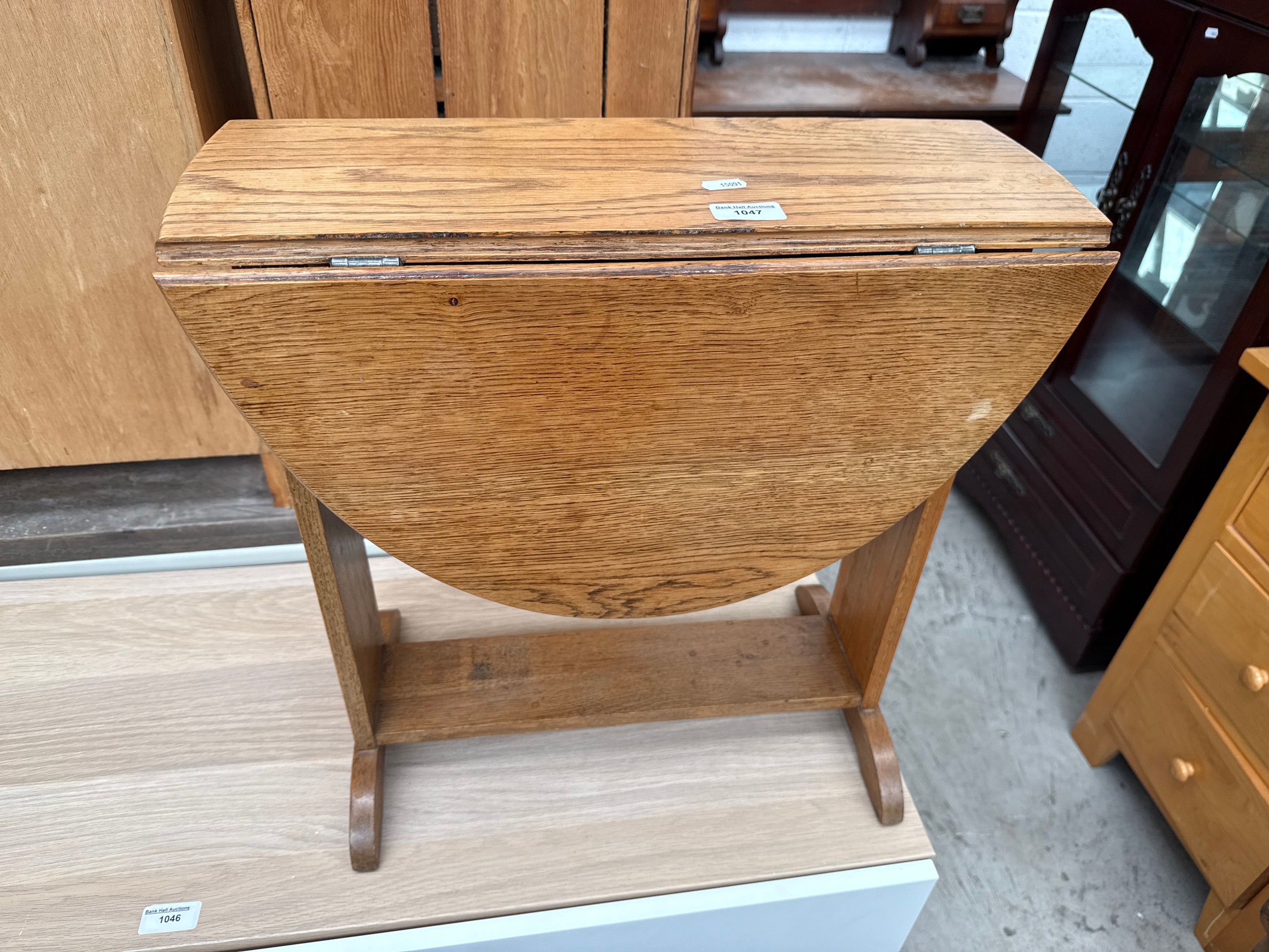 A small light oak swivel top drop leaf occasional table