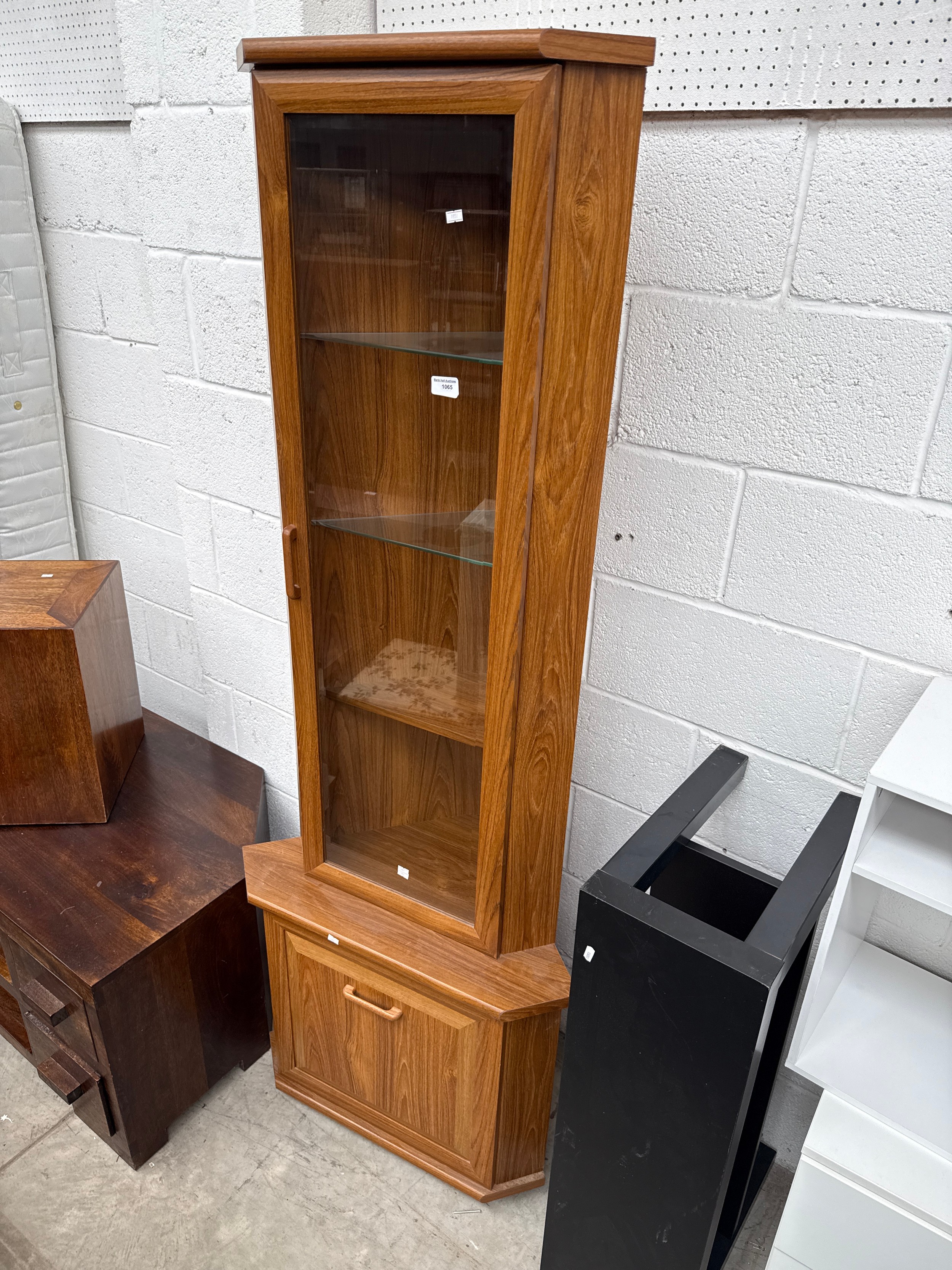 A modern glazed corner cabinet