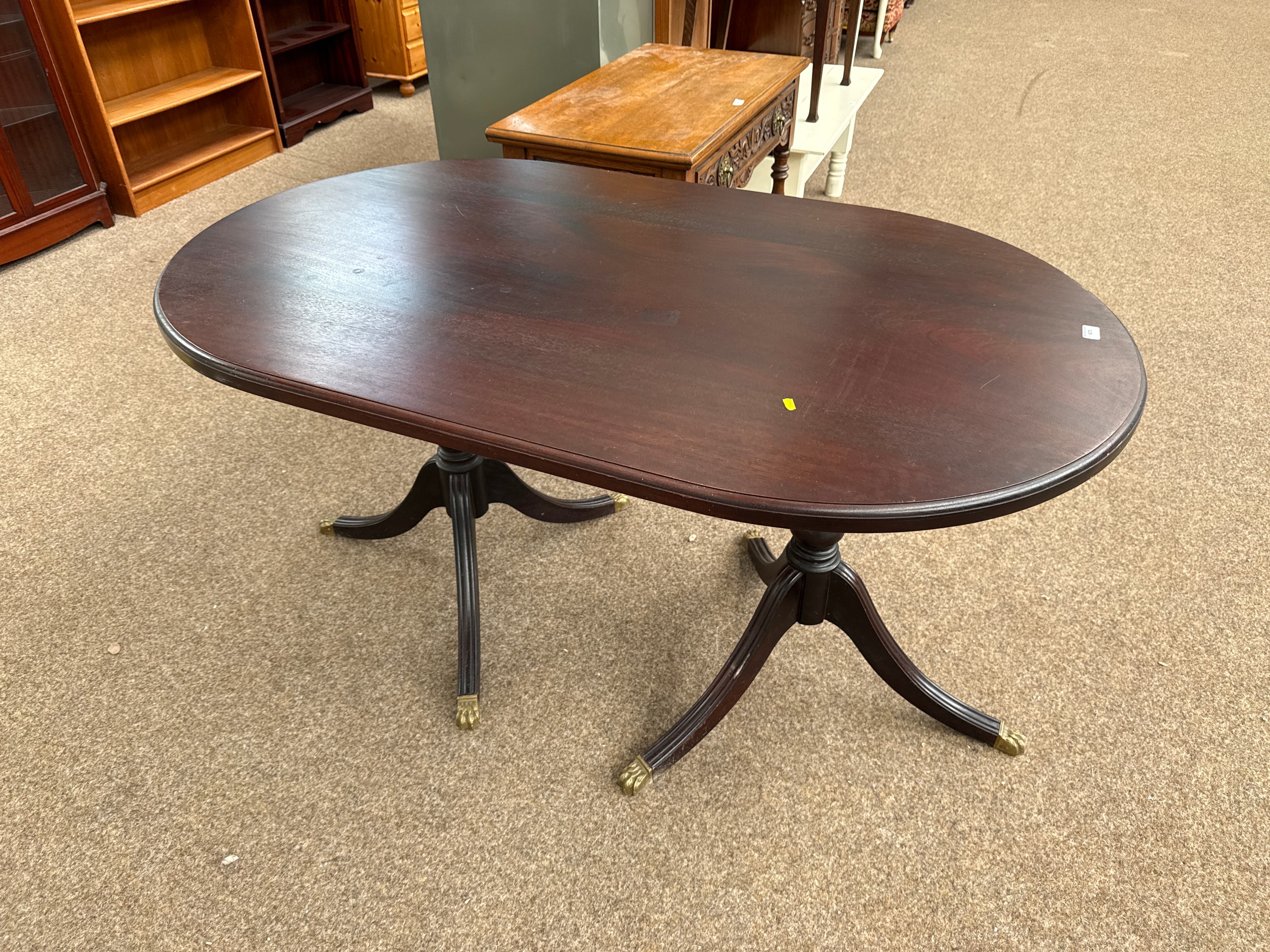 A large vintage oval mahogany twin pedestal dining table on splayed leg stands