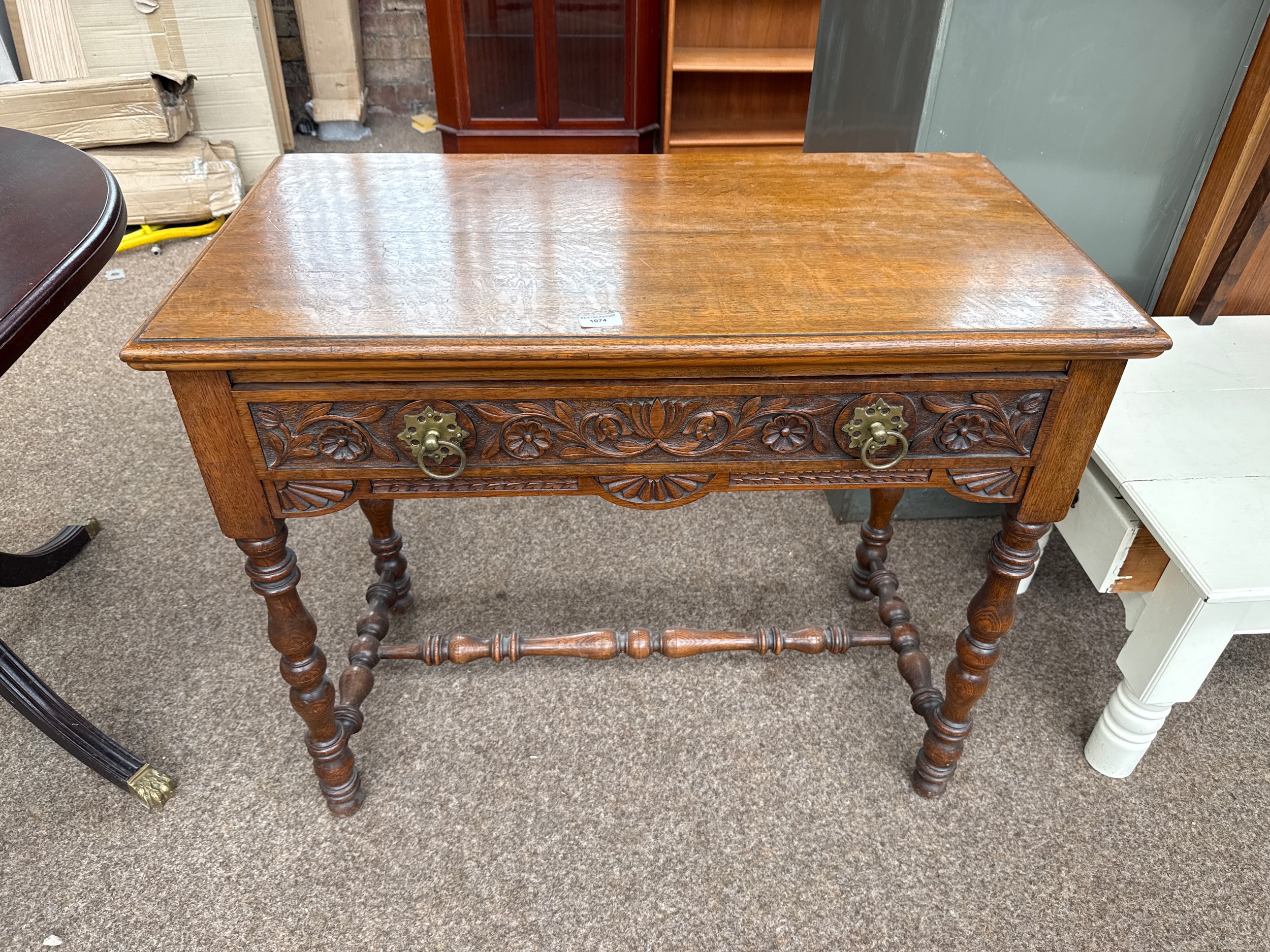 A vintage oak Lowboy with ornately carved drawer and side panels and bobbin