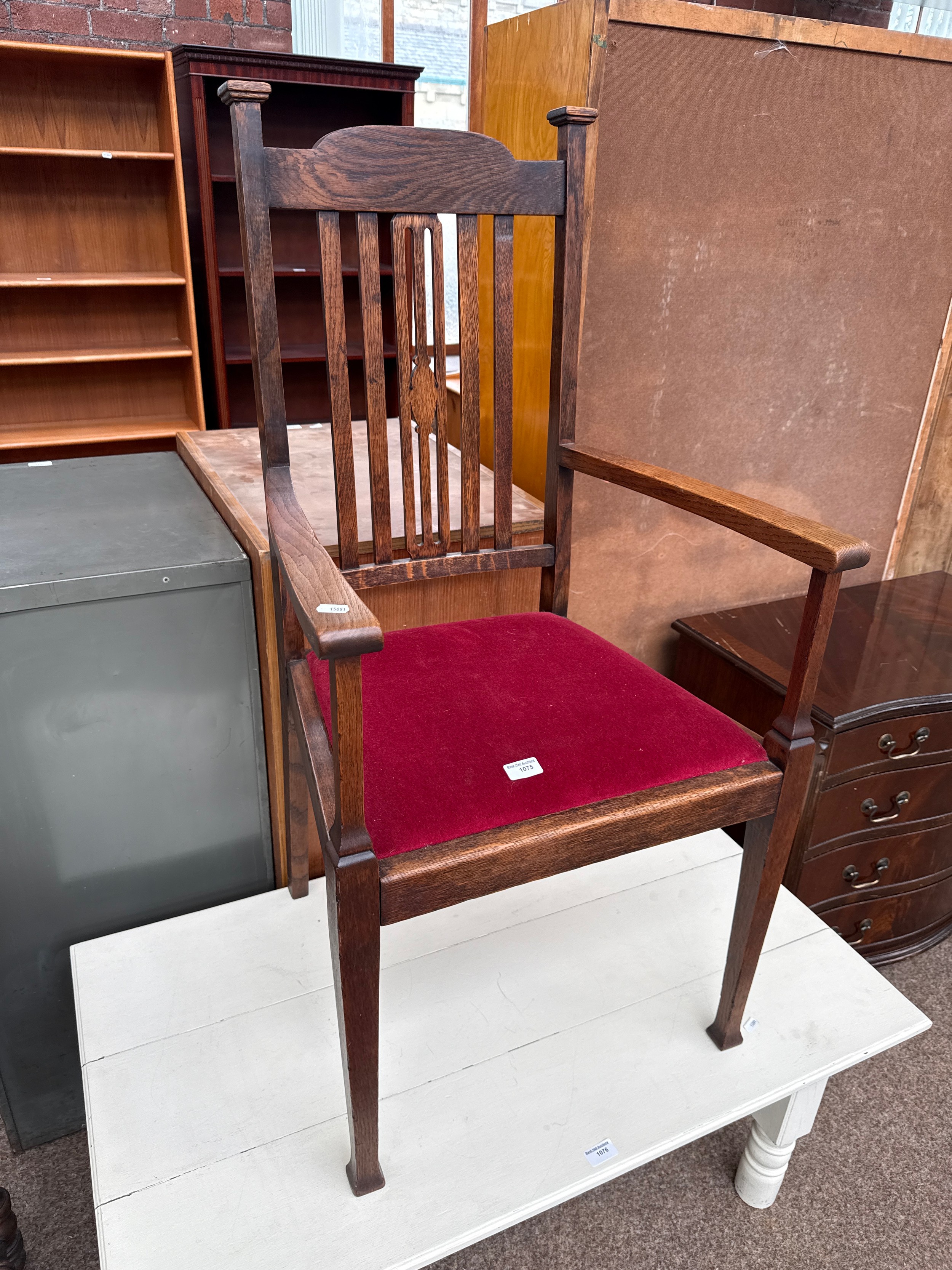 A vintage oak elbow chair with upholstered seat