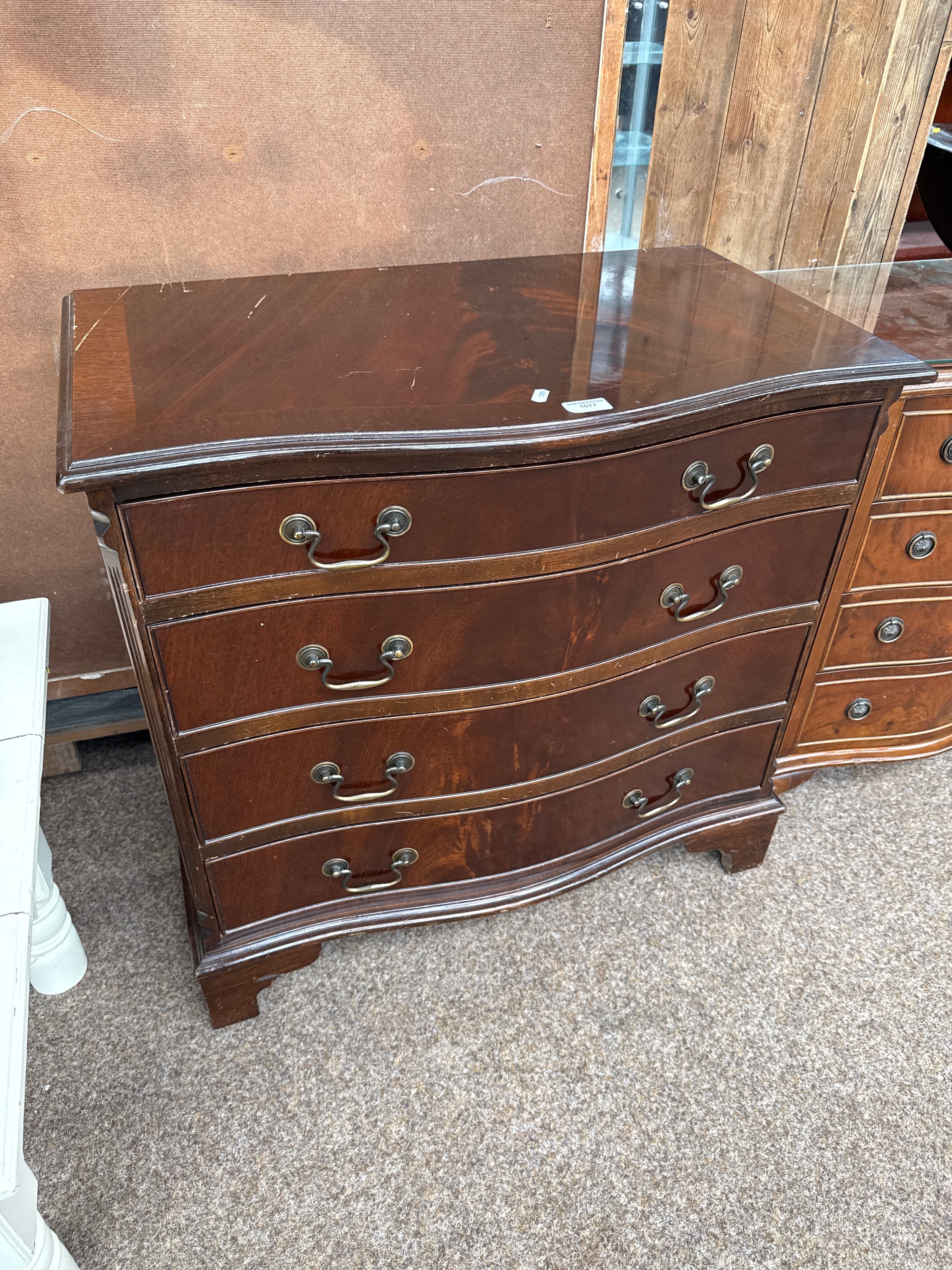 A vintage flame mahogany serpentine fronted 4 drawer chest