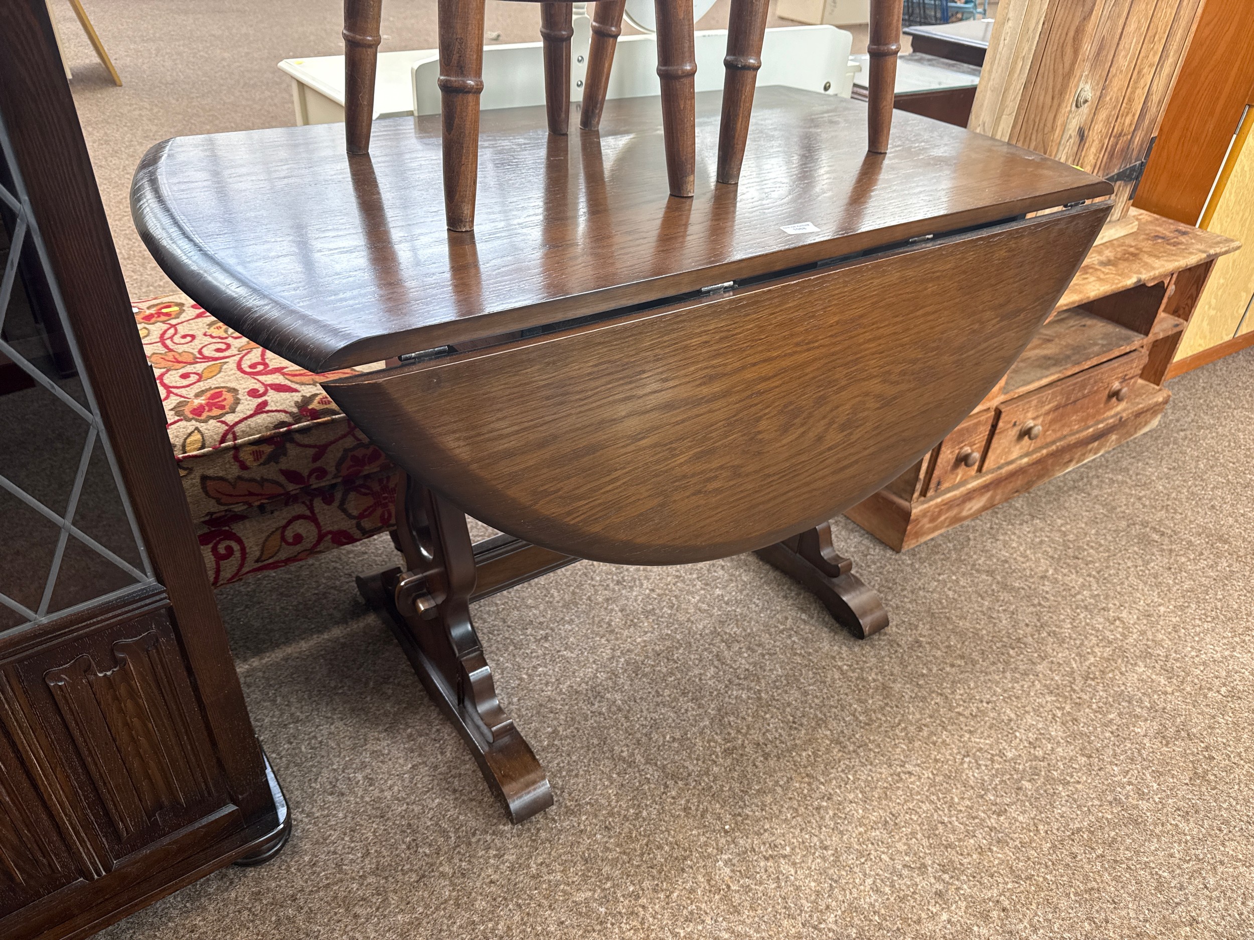 A large vintage circular drop leaf refectory style dining table