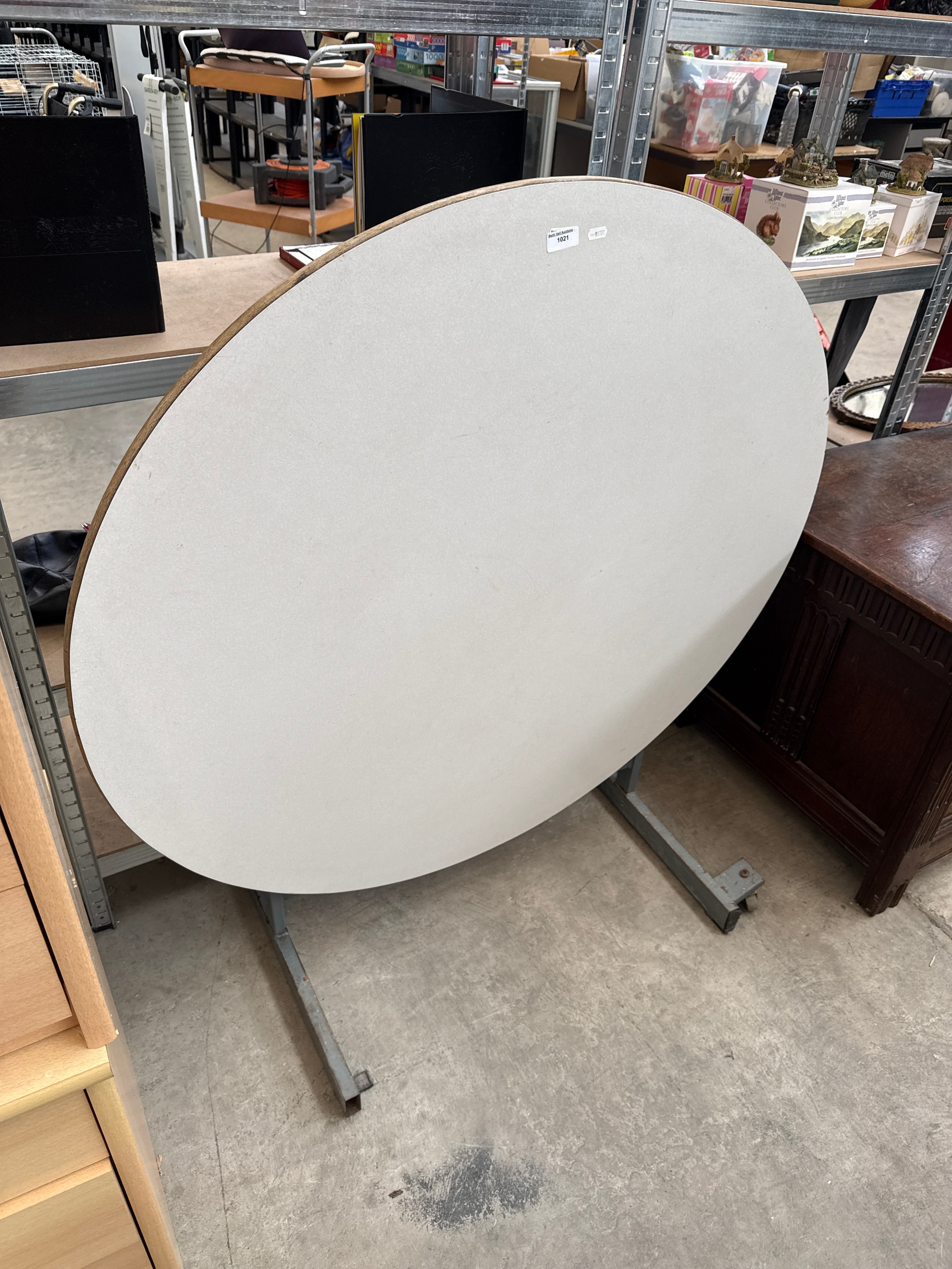 A large circular tilt top events table on metal frame