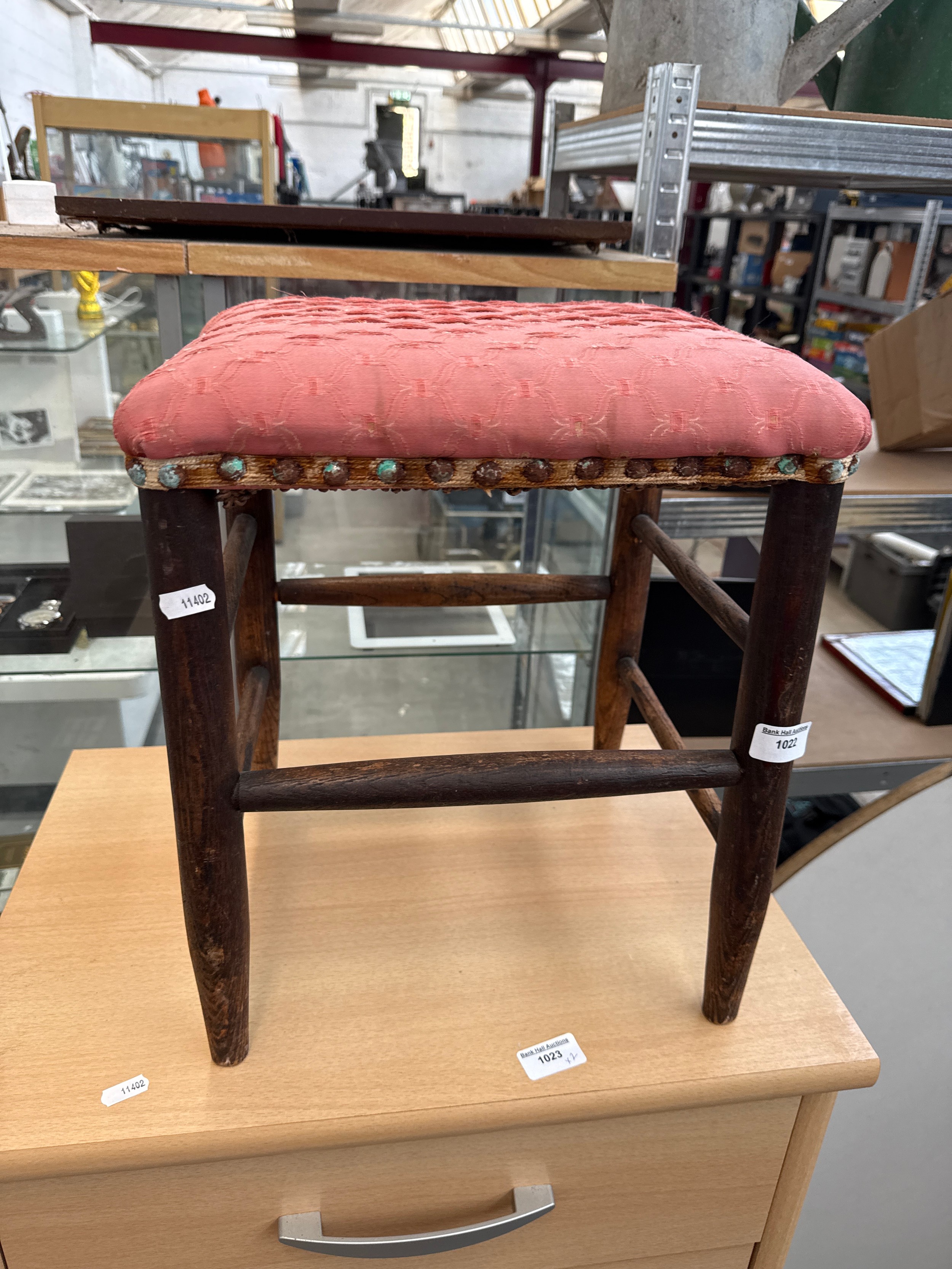 A small vintage stool with upholstered seat