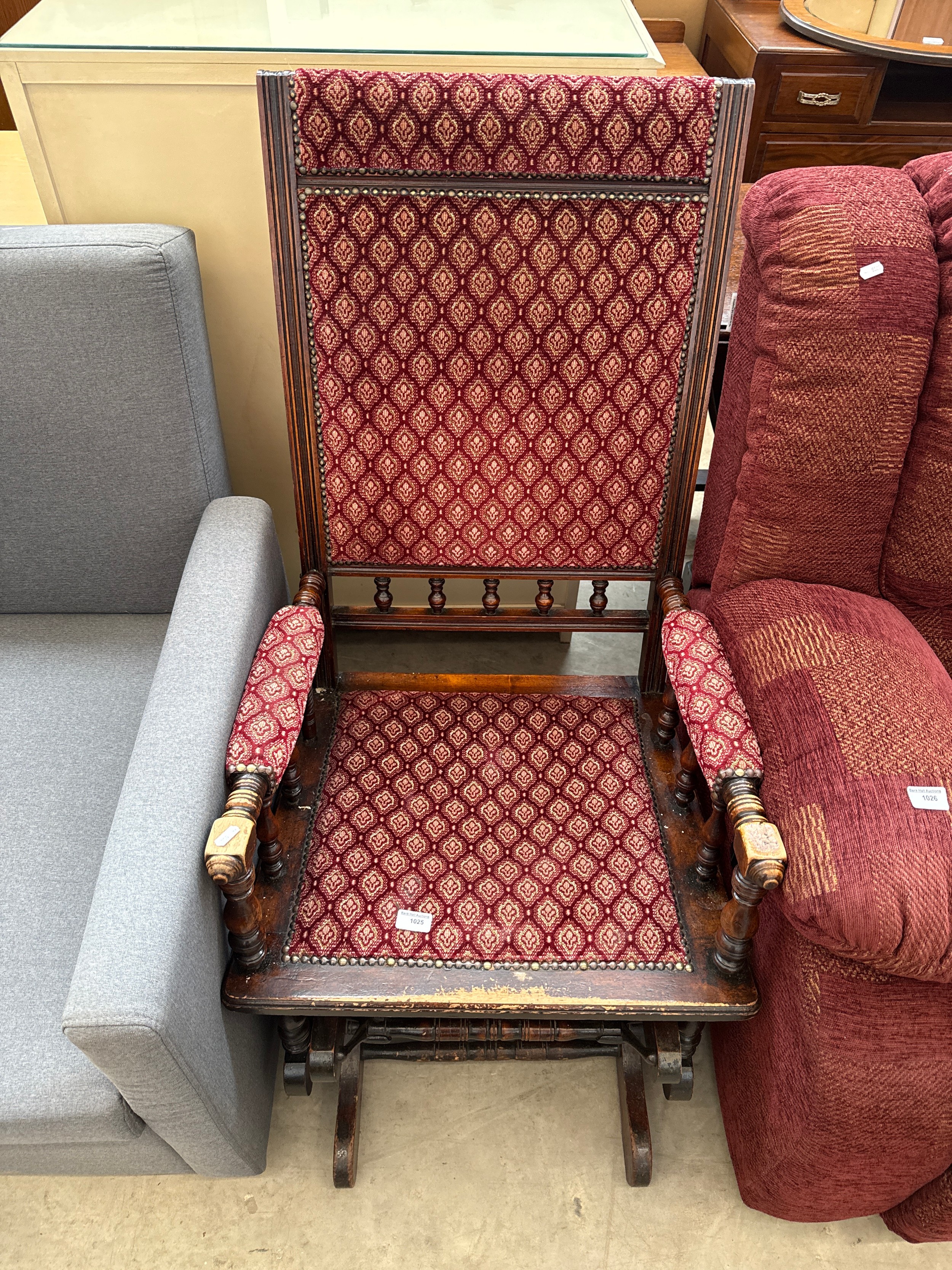A vintage bobbin turned wood framed rocking chair with upholstered seat pads