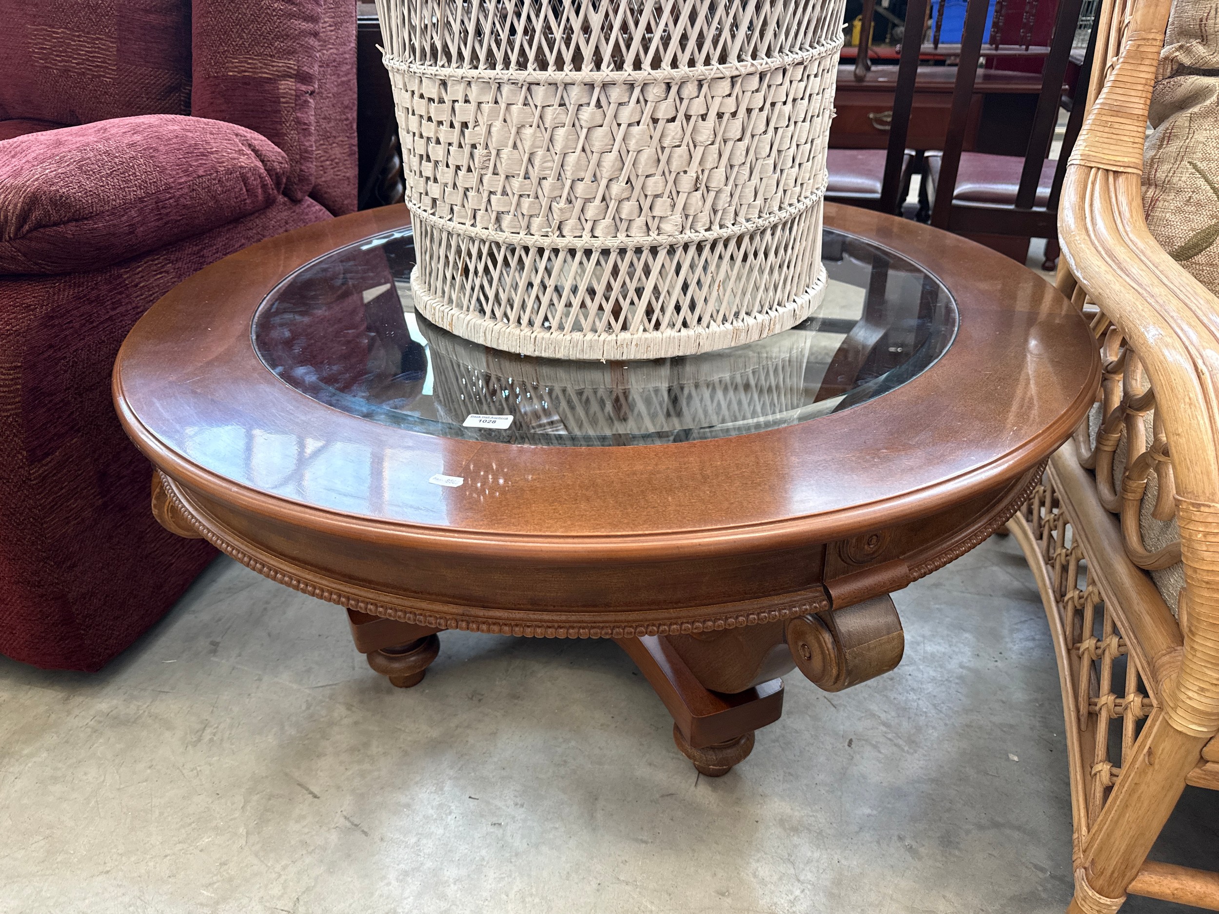 A large circular coffee table with glass top insert