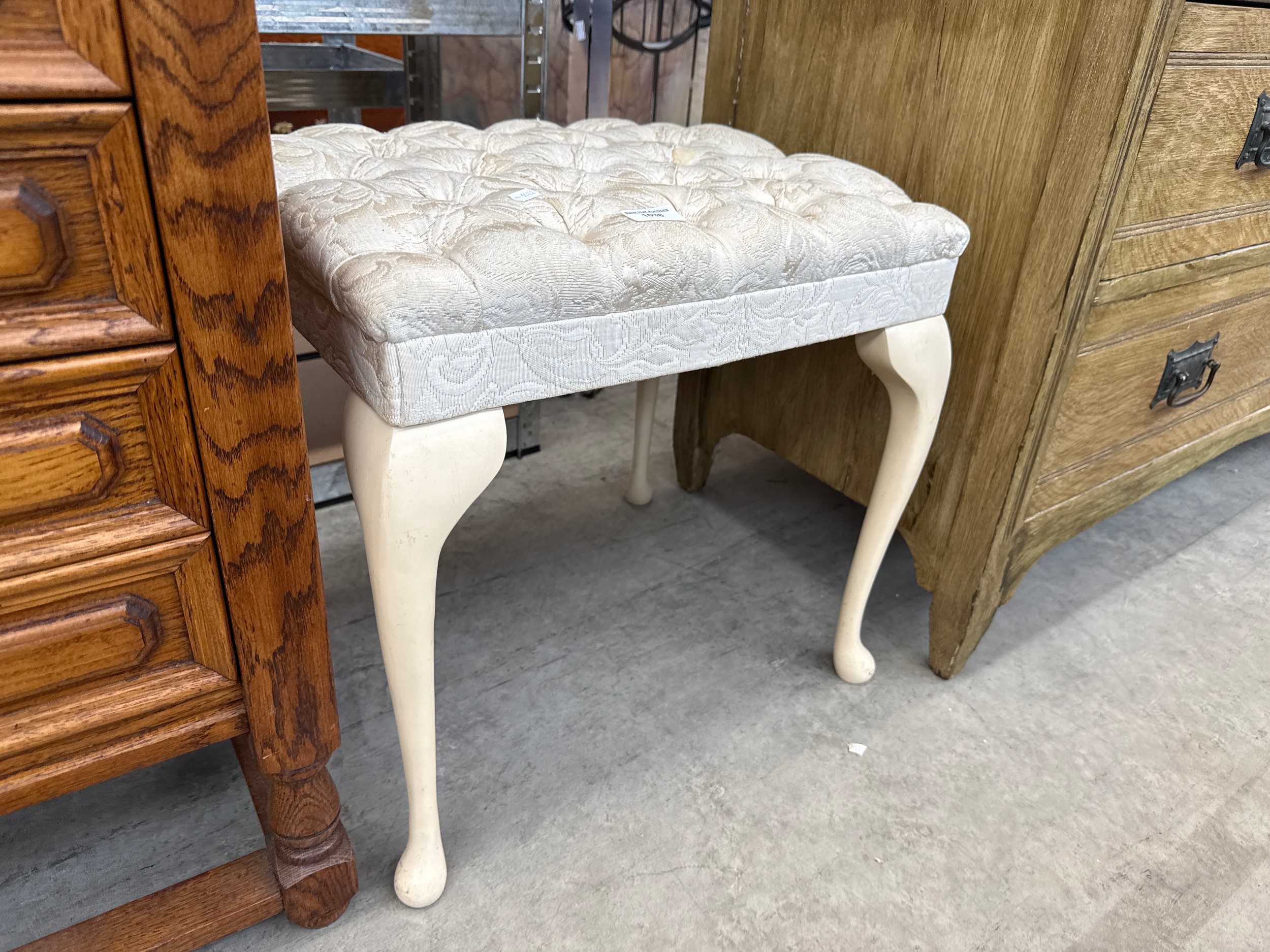 A vintage dressing table stool with upholstered seat