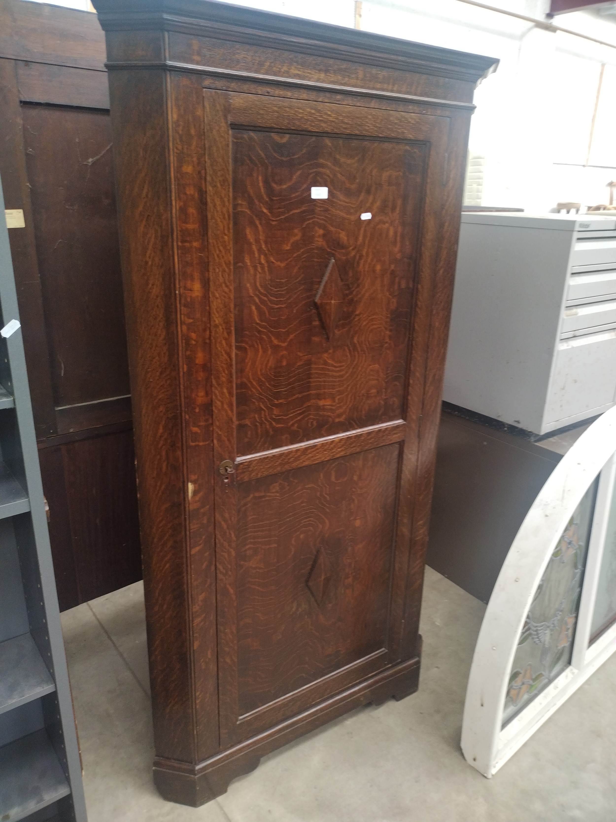 A large vintage oak shelved corner cupboard