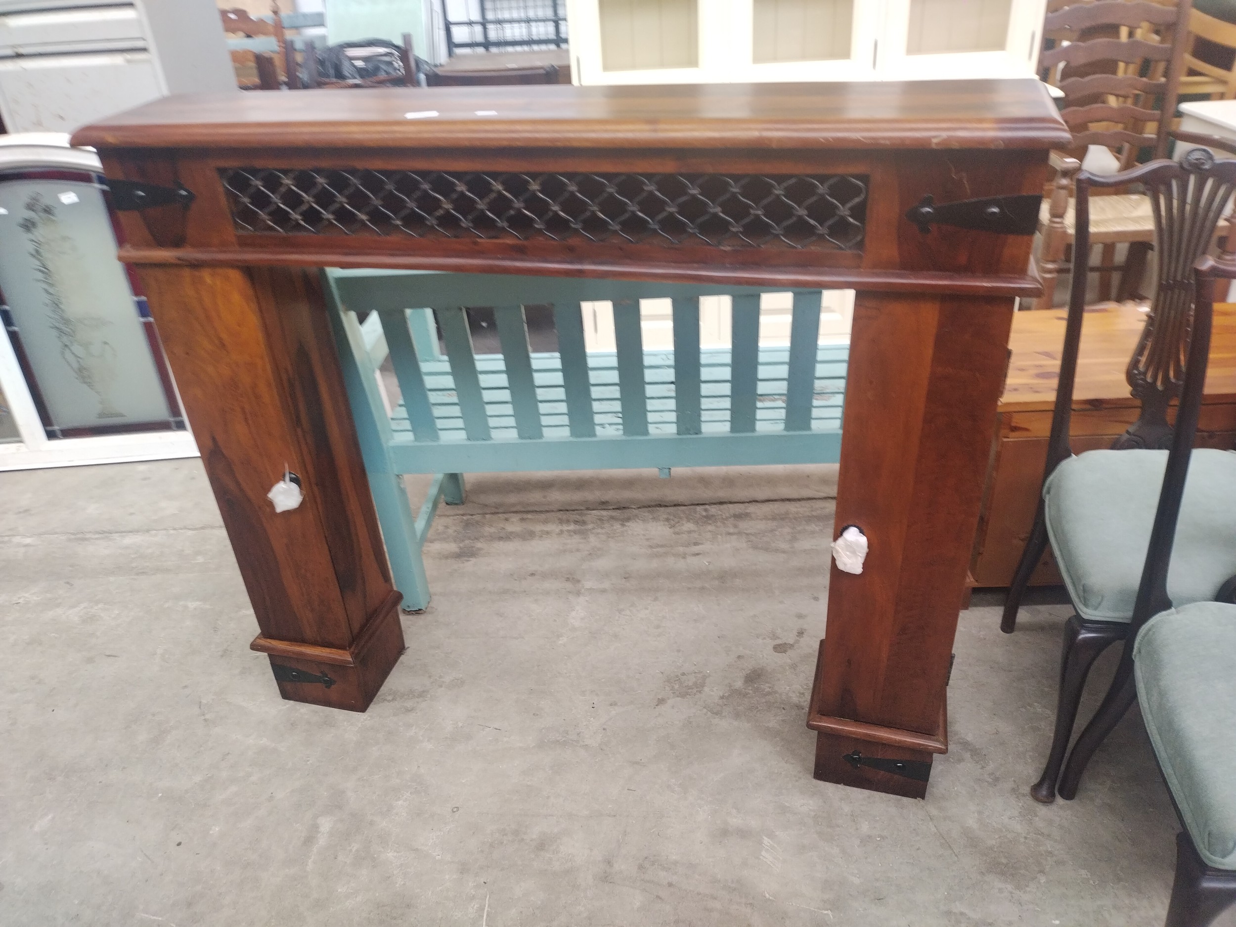 A Sheesham style fire surround with side storage towers