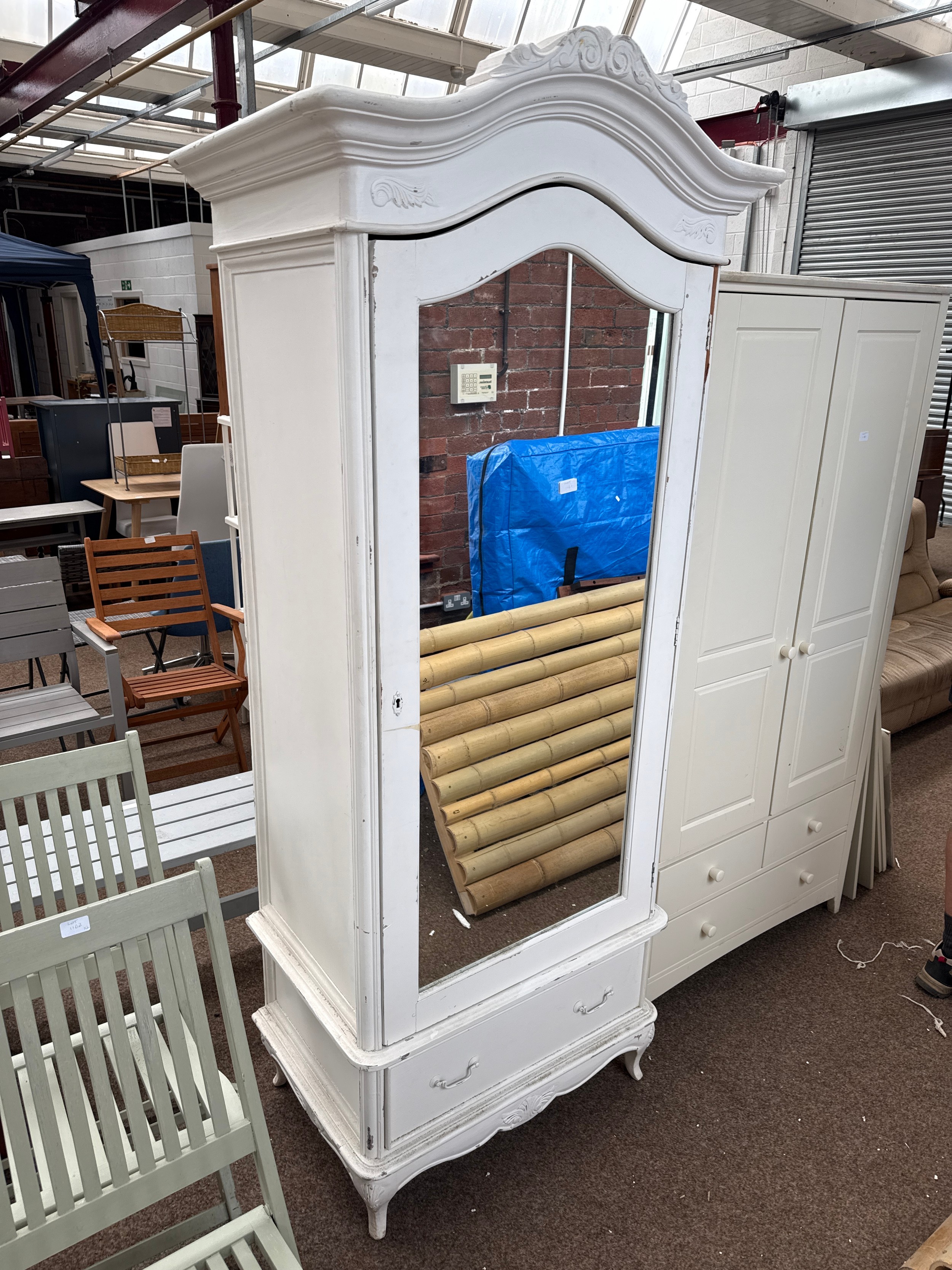 A painted vintage carved wardrobe with lower drawer and mirrored door