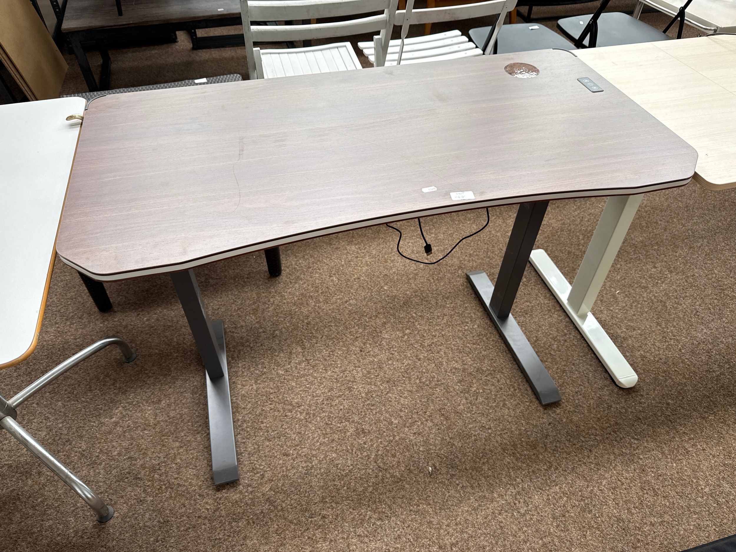 A small modern computer desk with built in light strip around edges, working