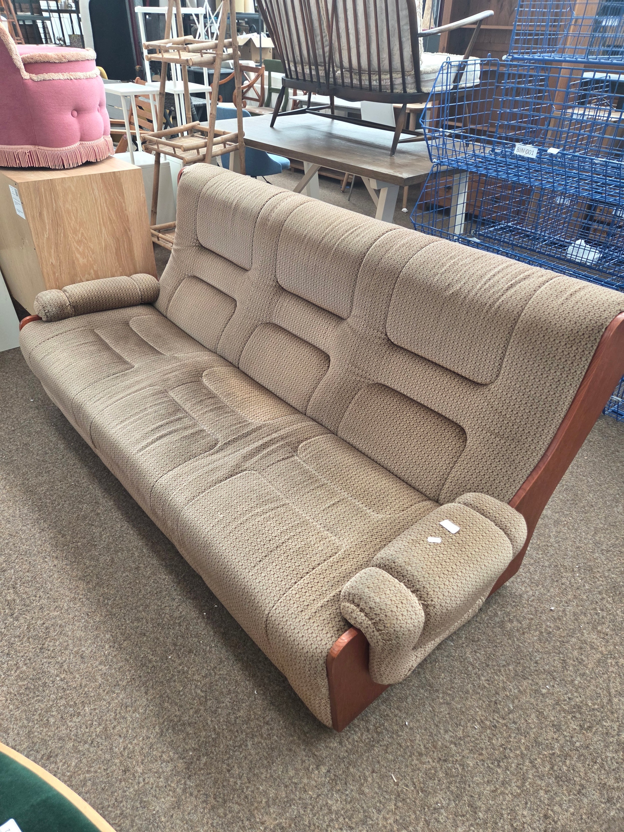 A large vintage wood framed settee with cushioned seats
