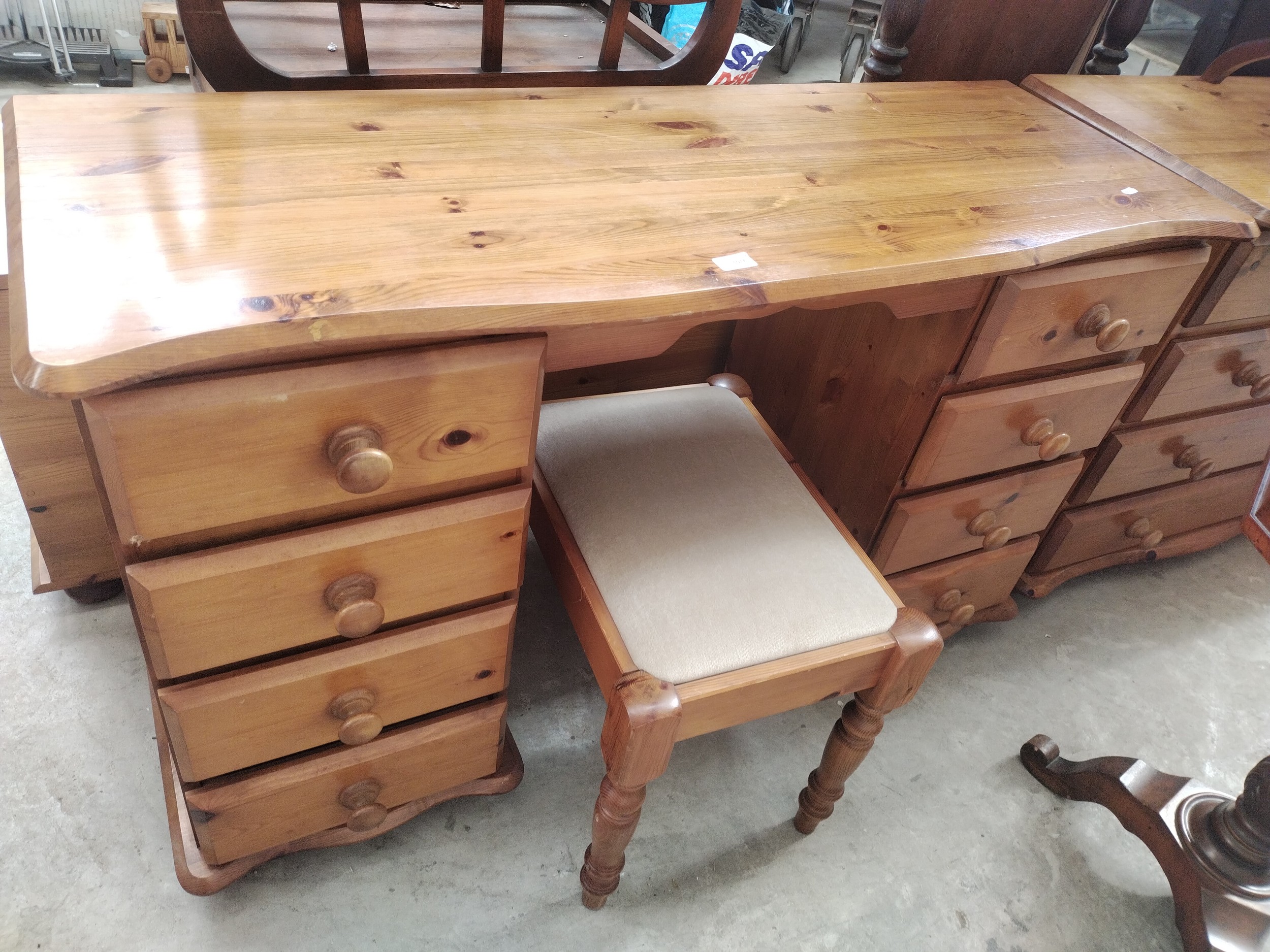 An 8 drawer pine dressing table with stool