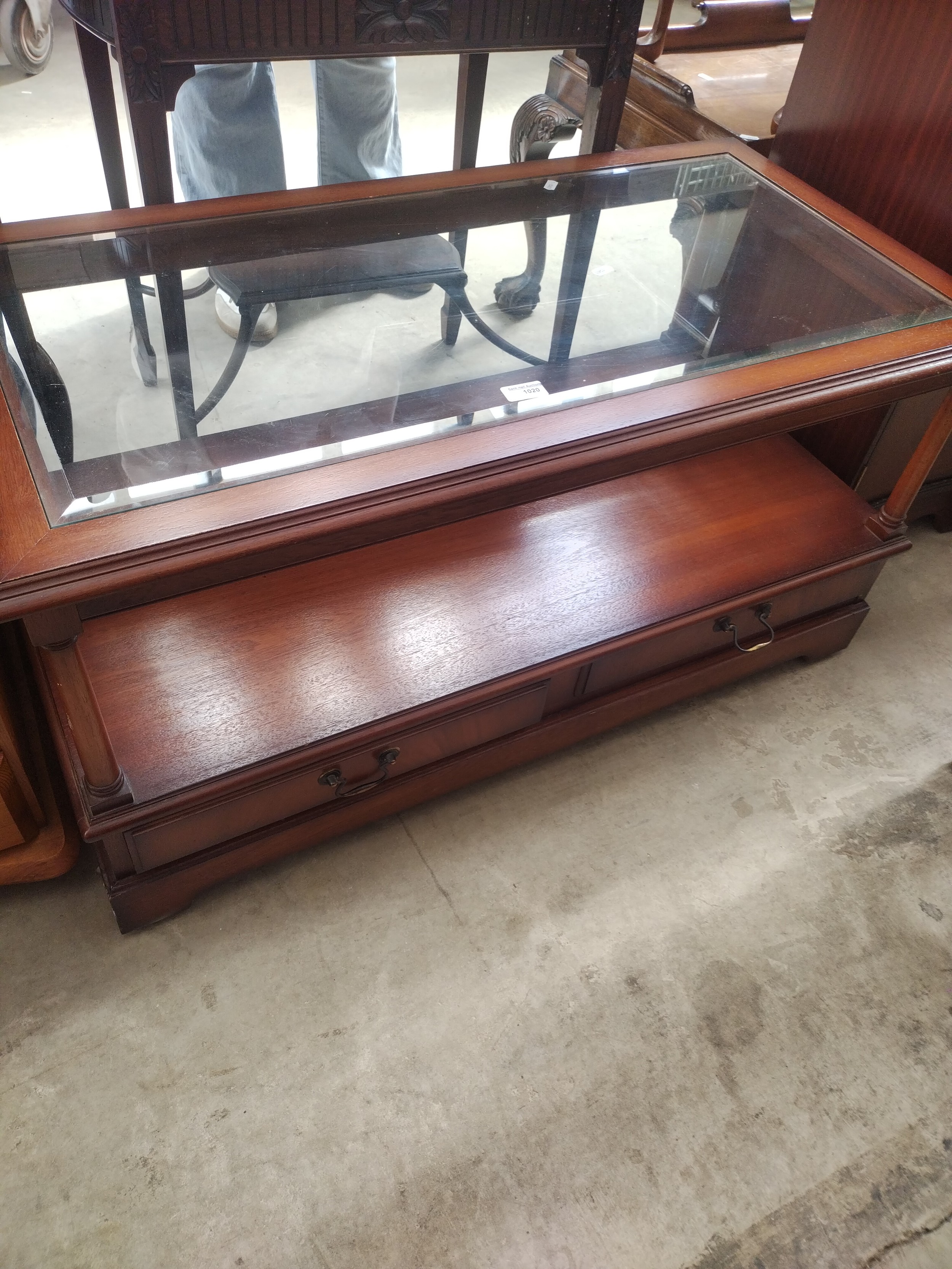 A vintage glass topped coffee table with lower drawers