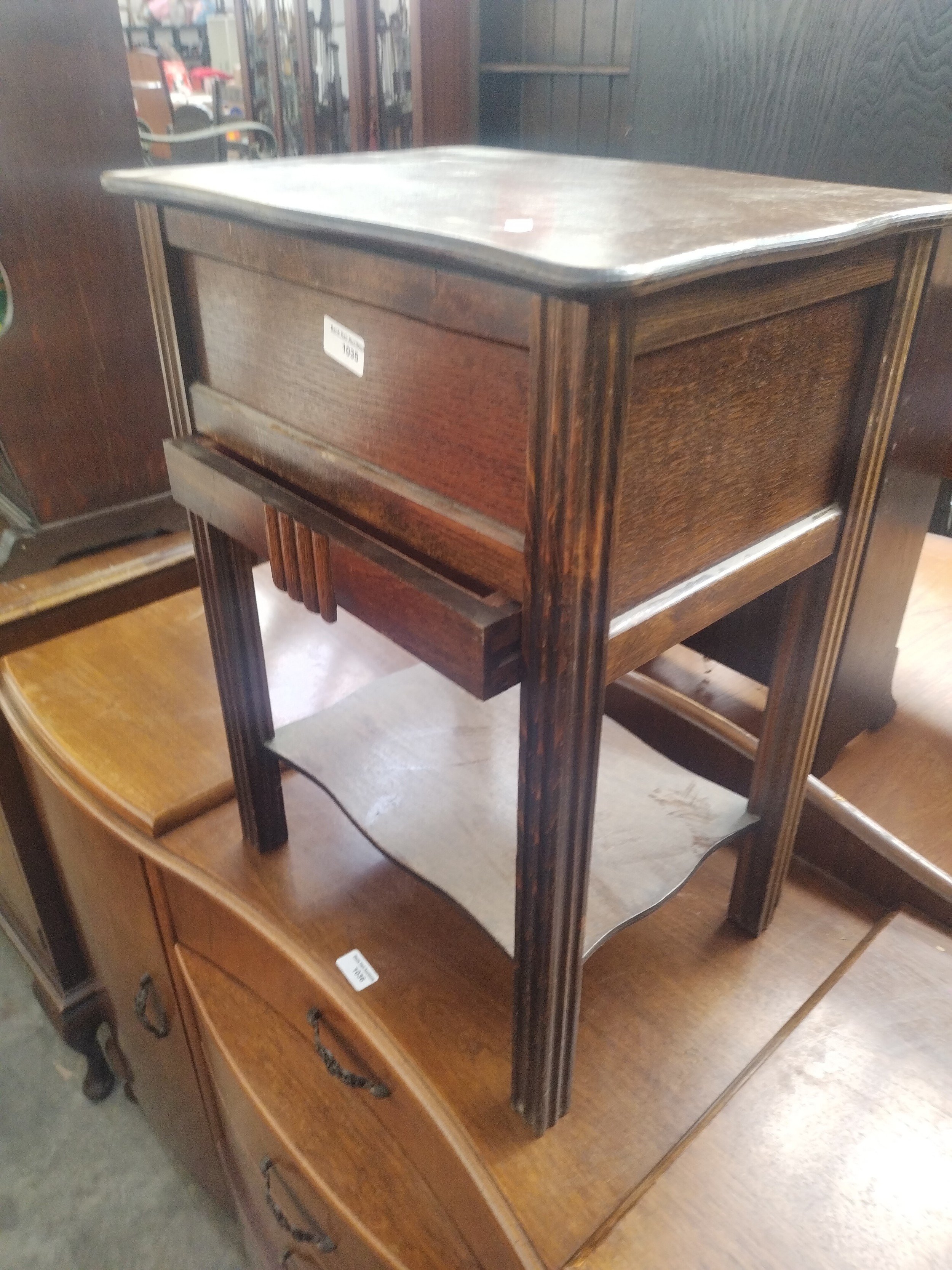 A vintage oak lift top sewing box with lower drawer