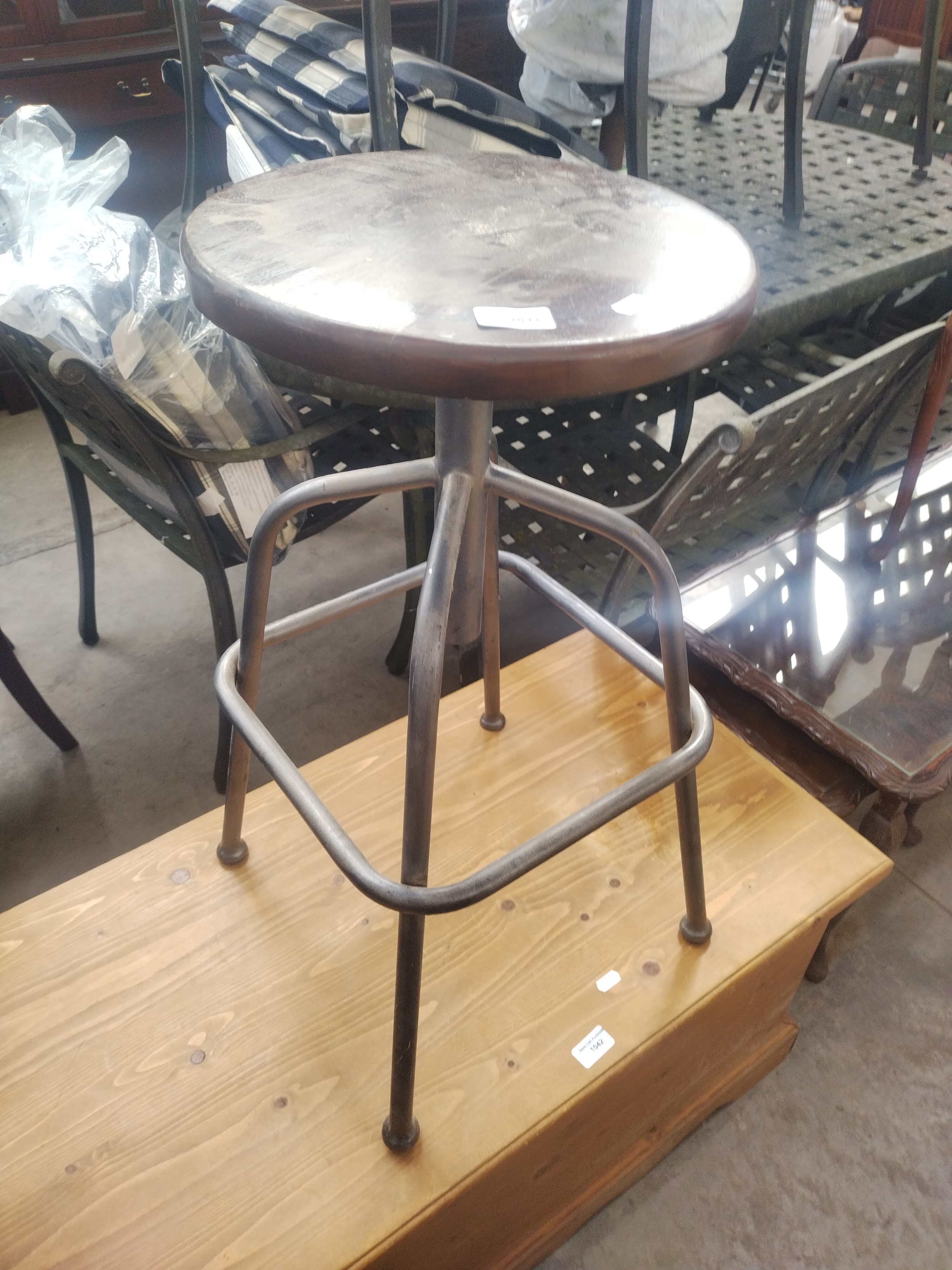 A vintage adjustable wood seated bar stool with metal frame