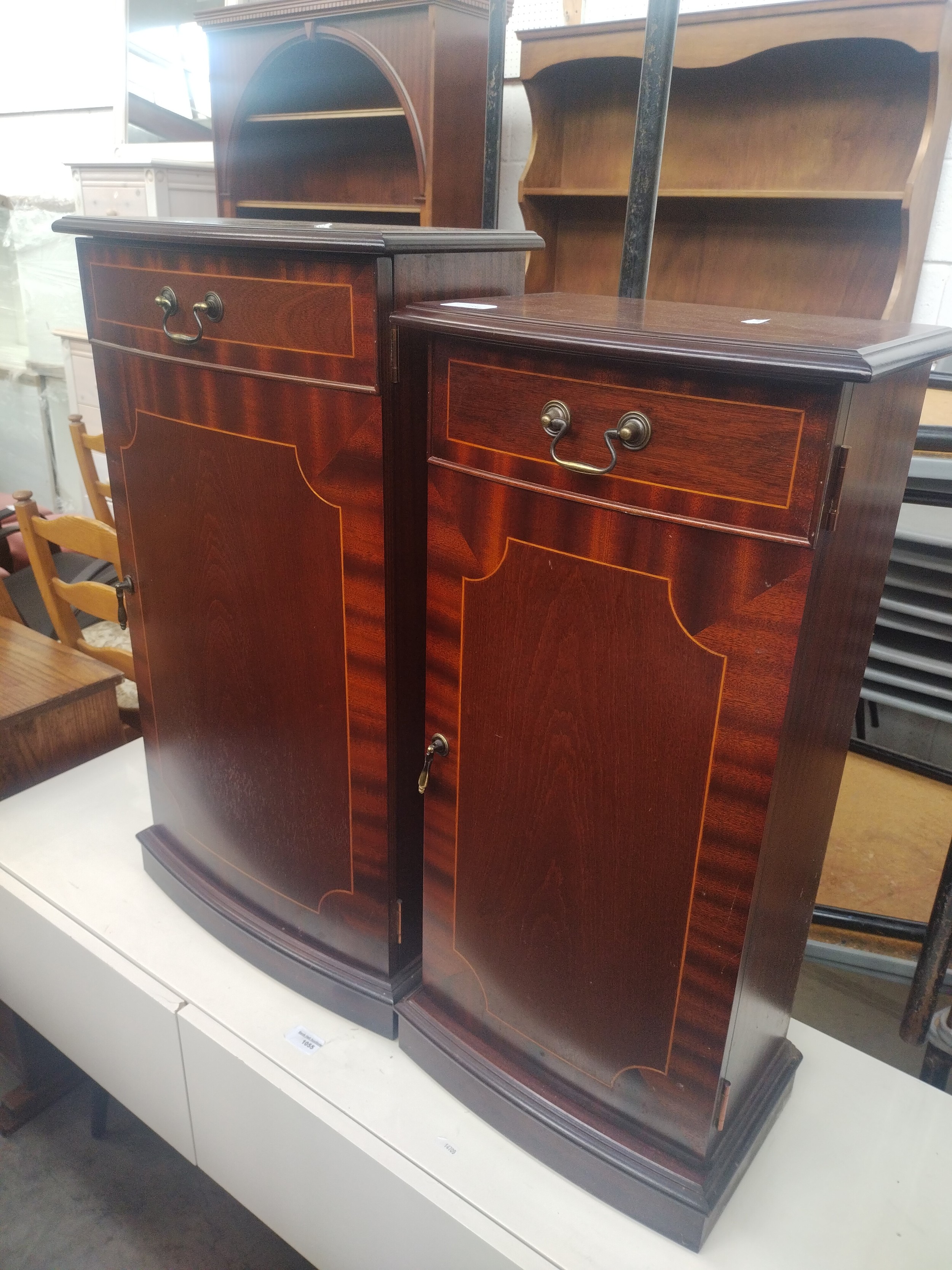 A small mahogany single door DVD storage tower cabinet and a similar shelved