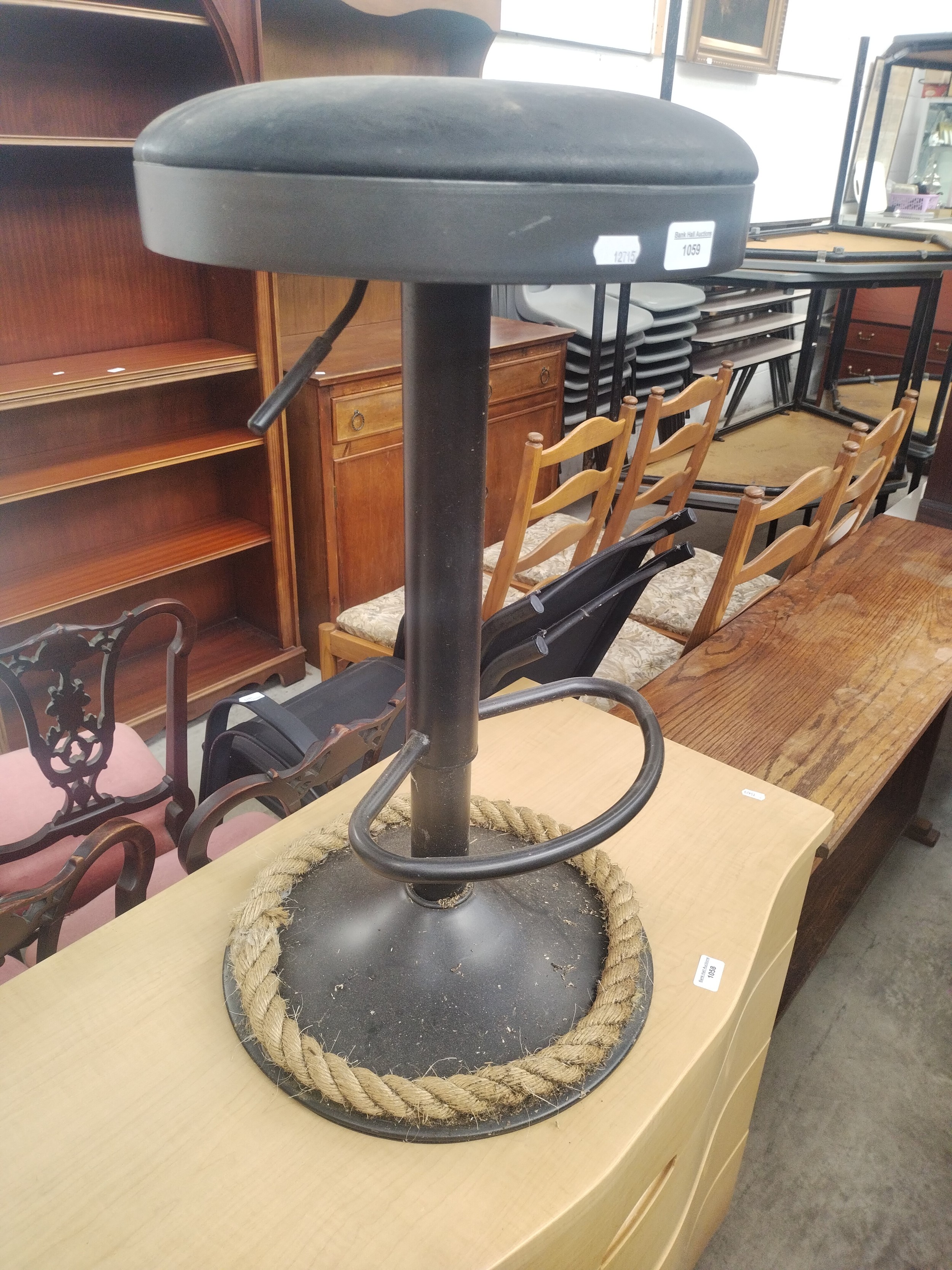 An adjustable metal framed bar stool with padded seat
