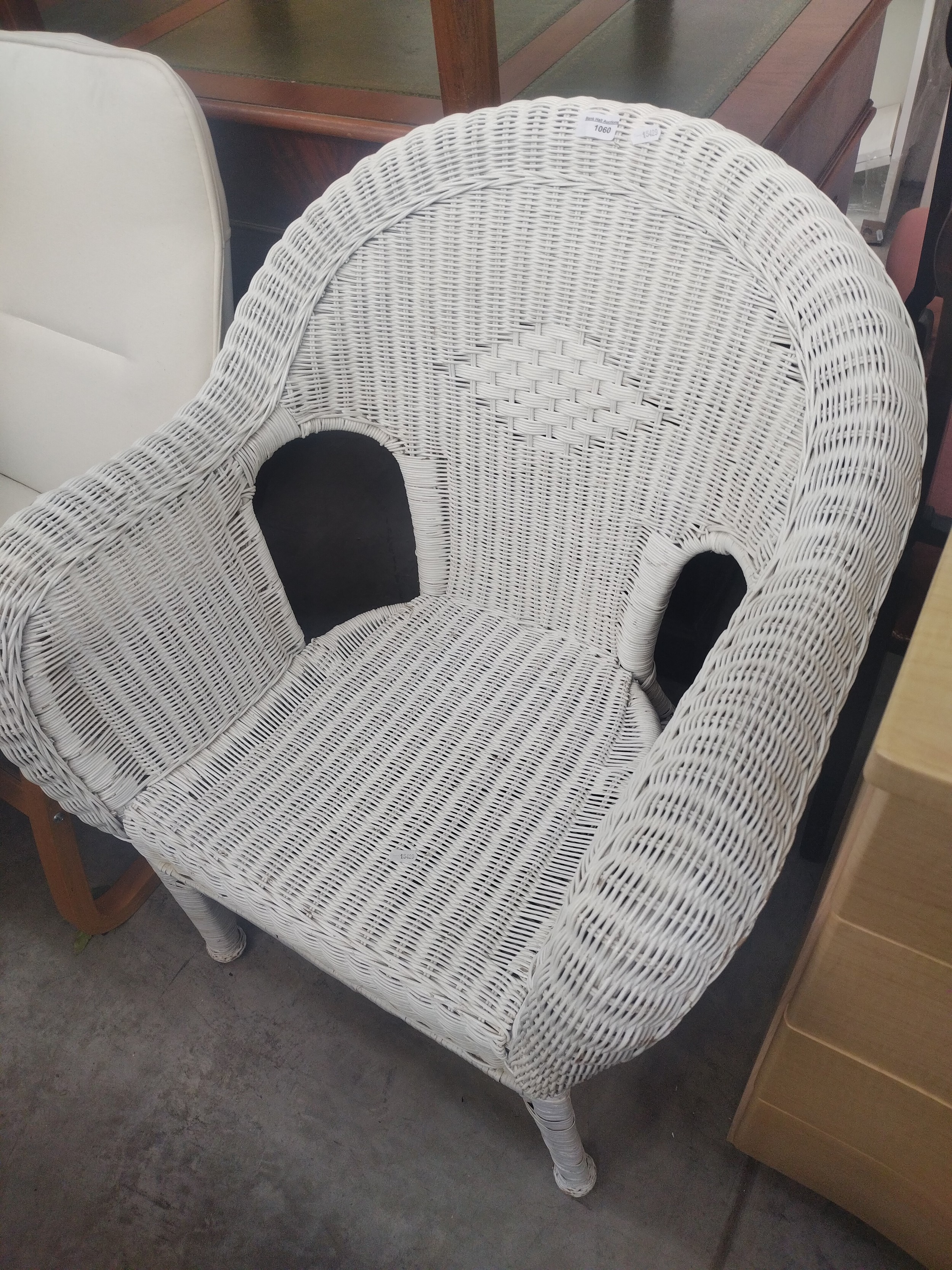 A large painted wicker basket armchair