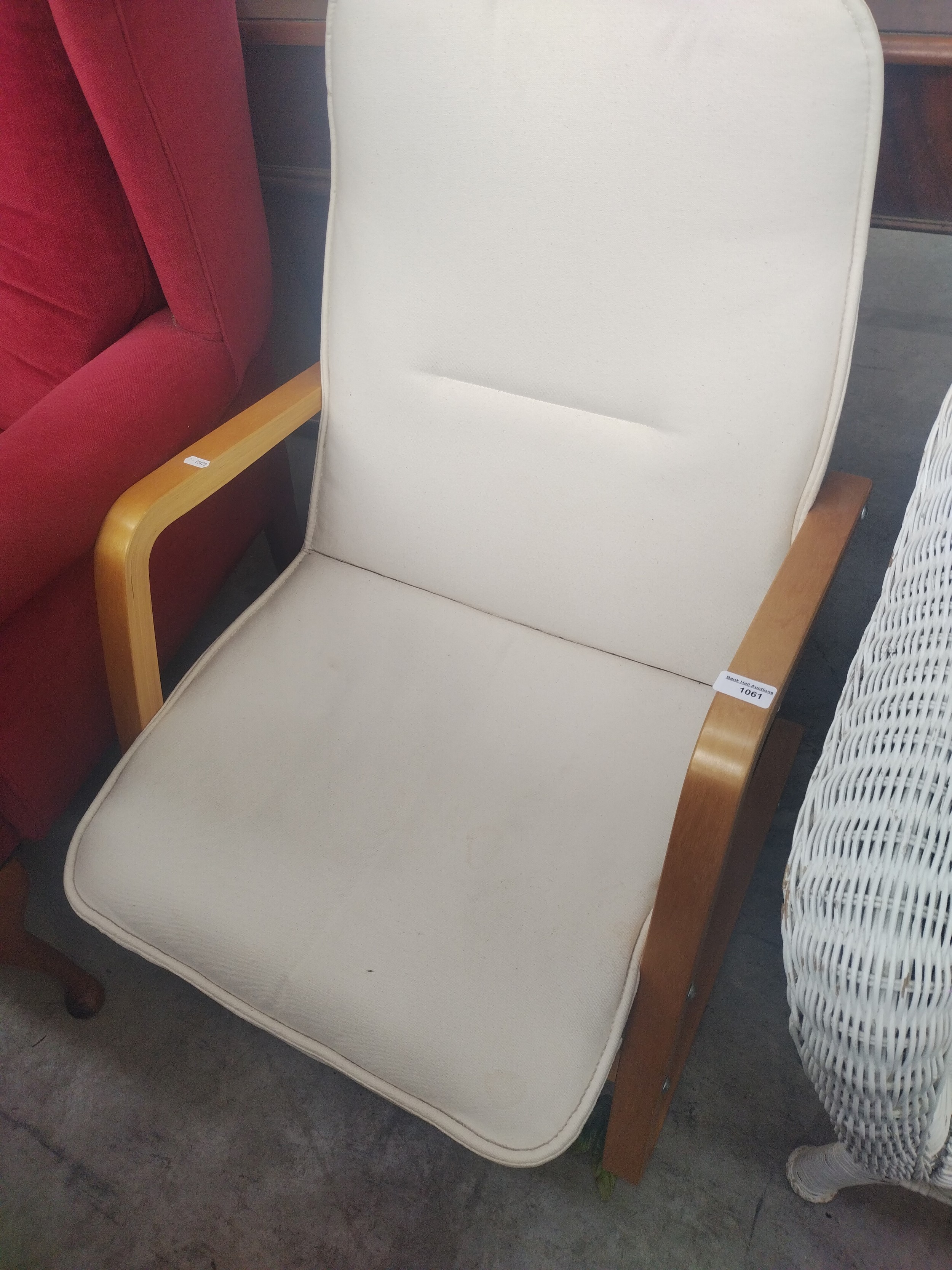 A modern wood framed elbow chair with cushioned seat