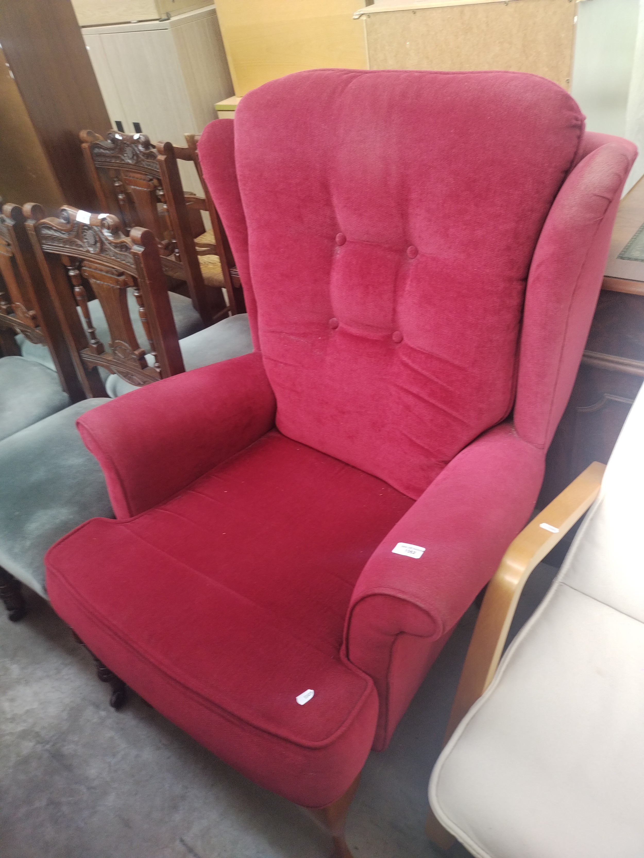 A vintage wing back upholstered fireside chair on Queen Anne style legs