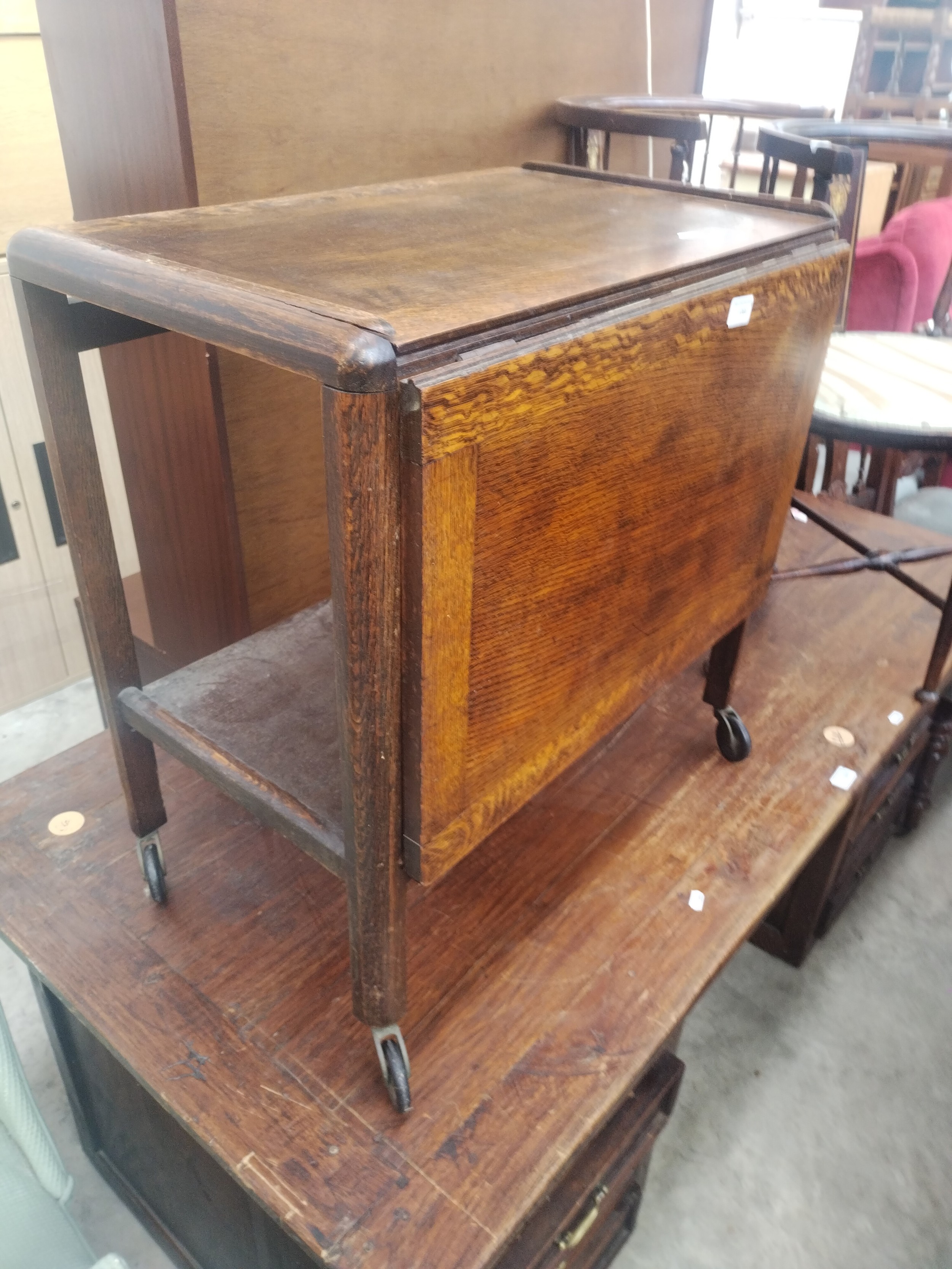 A vintage oak 2 tier tea trolley with extending drop leaf table top