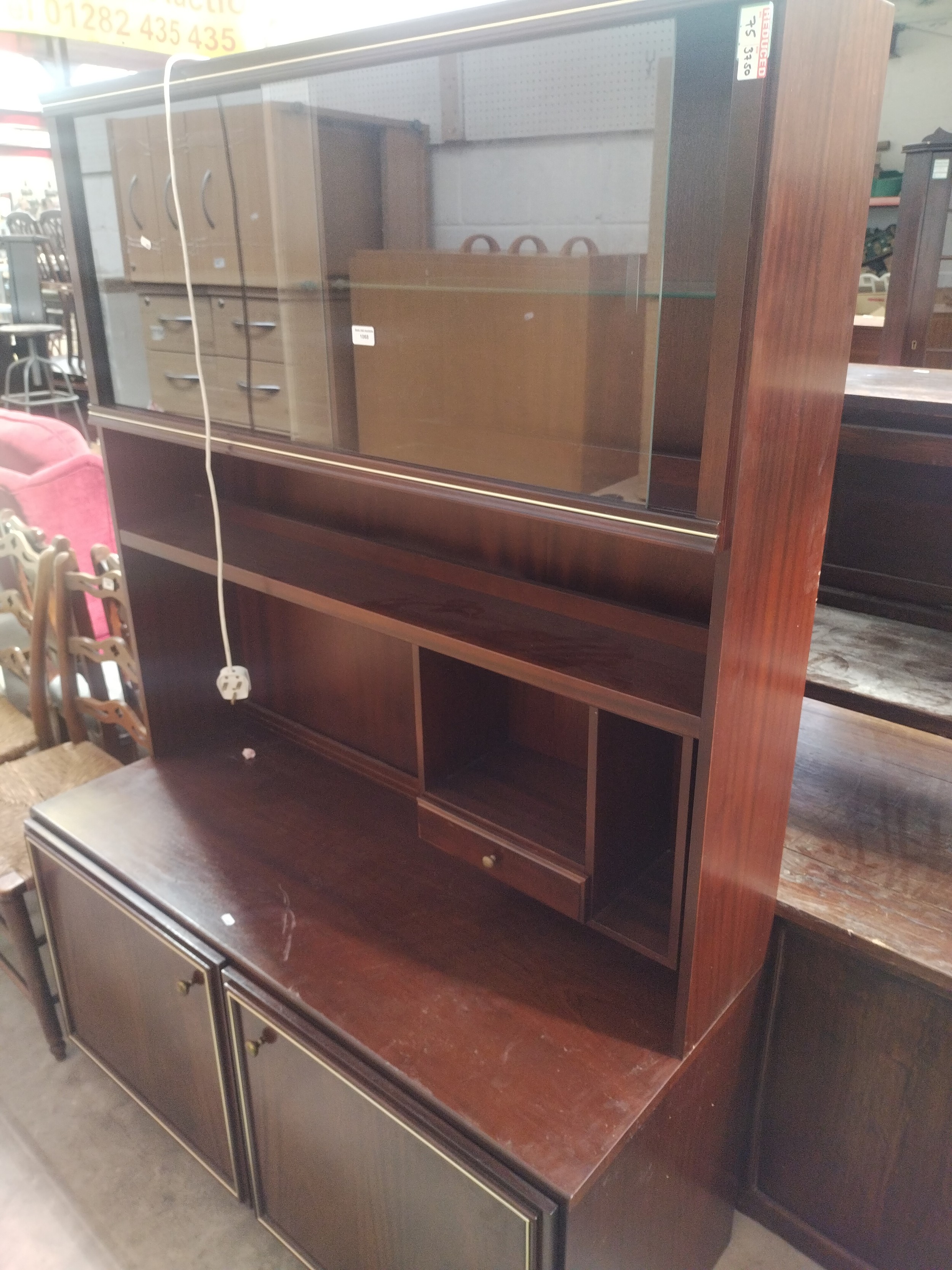 A large vintage mahogany wall unit with sliding glass upper doors