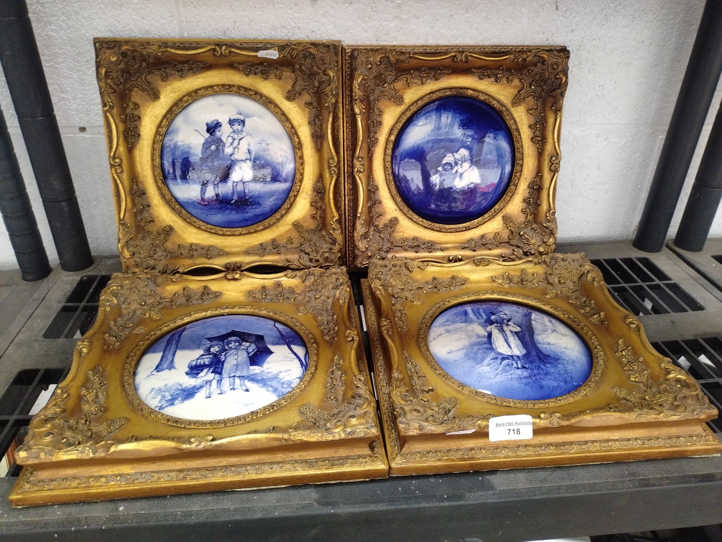 Four decorative gilt framed blue & white plates