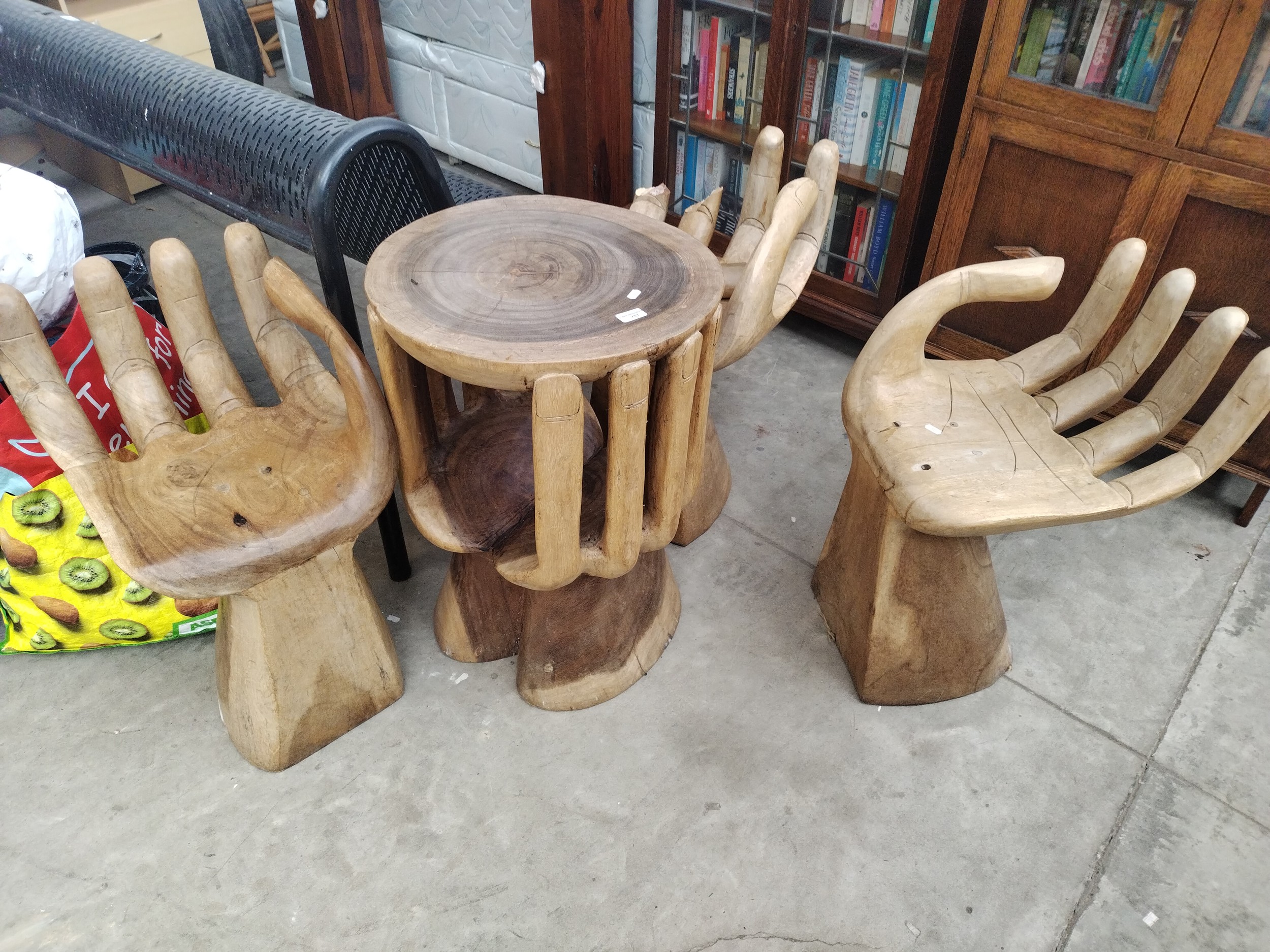 Three carved hand wooden stools and carved hands wooden table