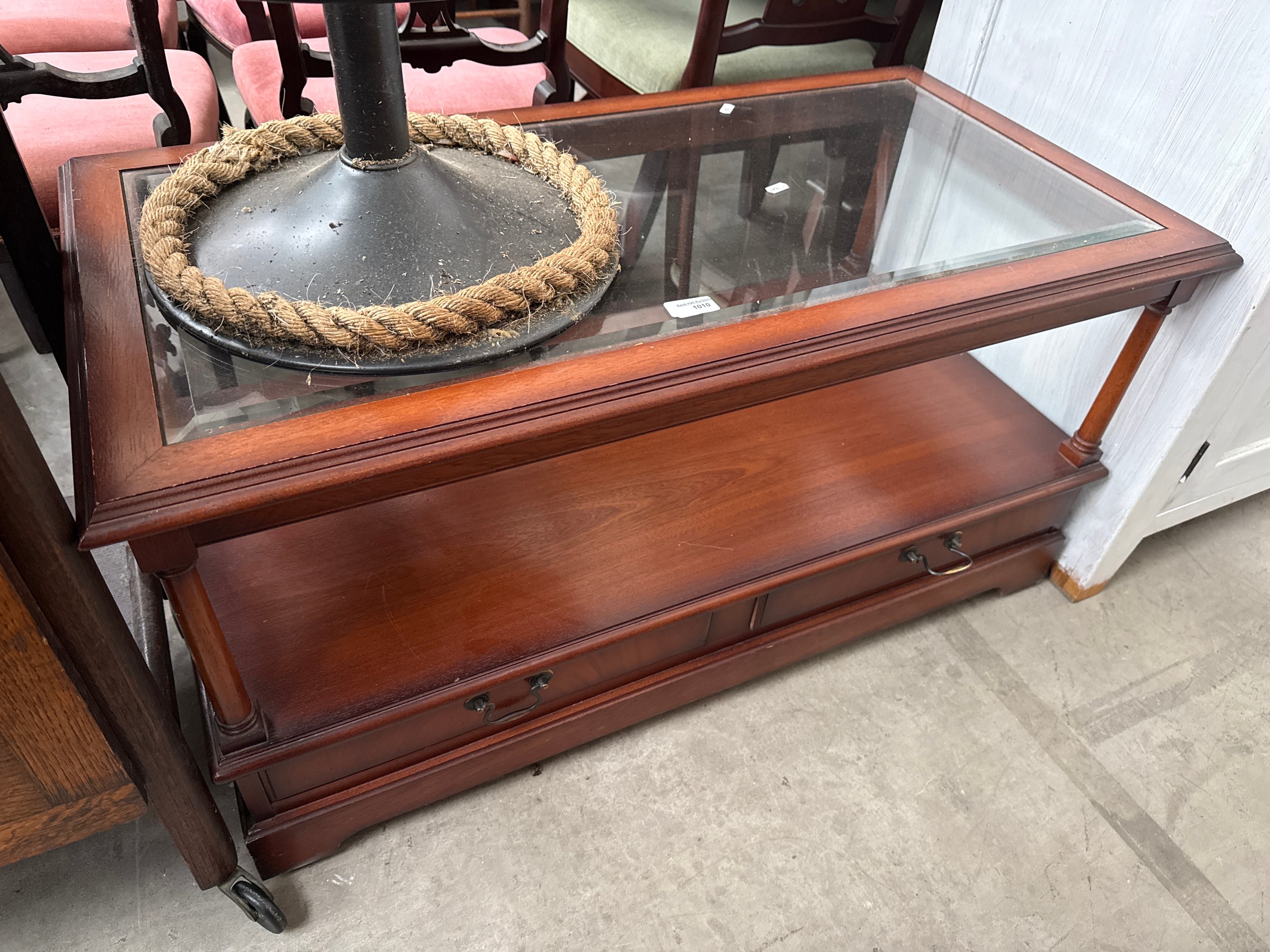 A retro glass top coffee table with lower drawers