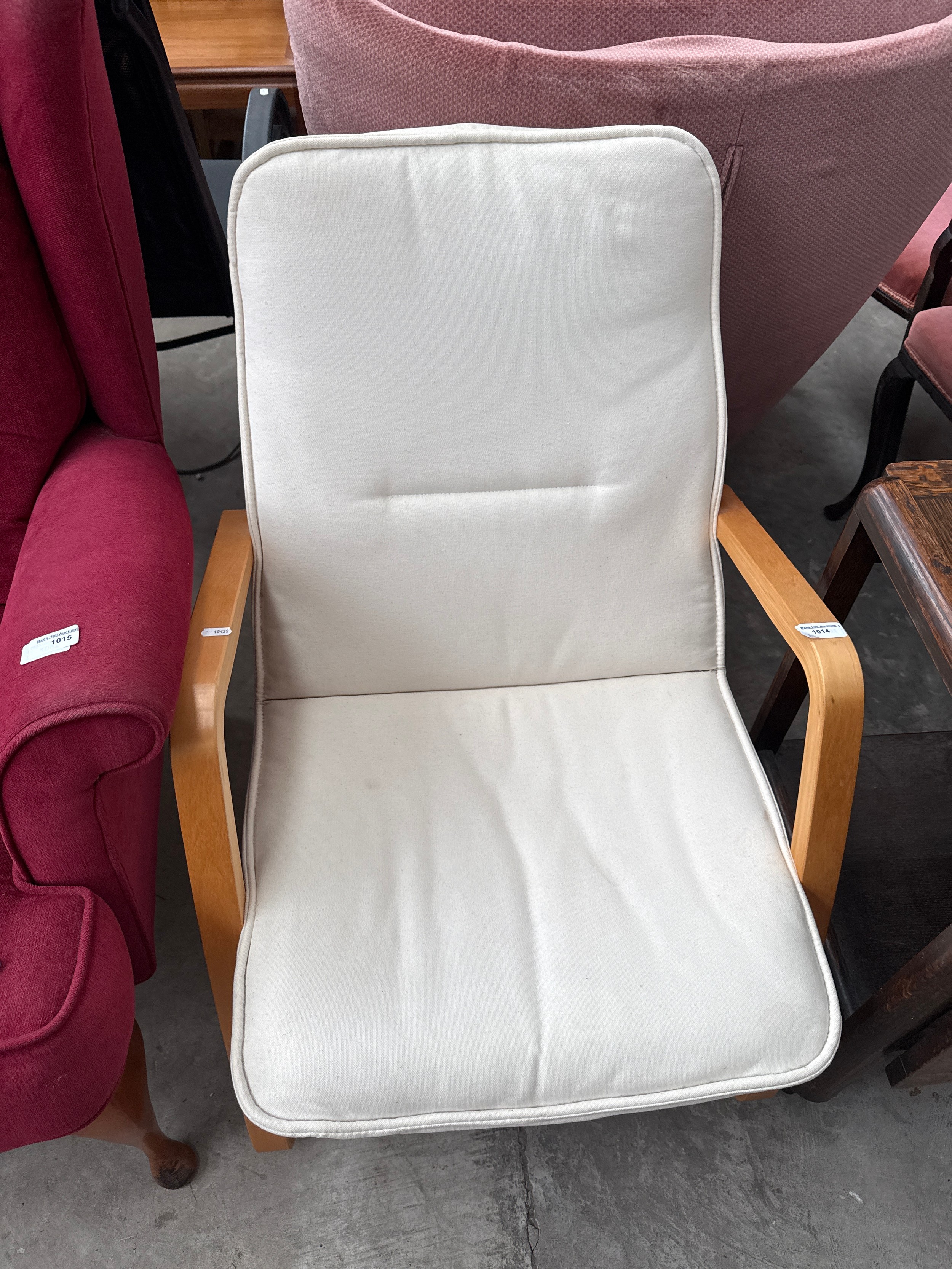 A wood framed lounger chair with padded seat