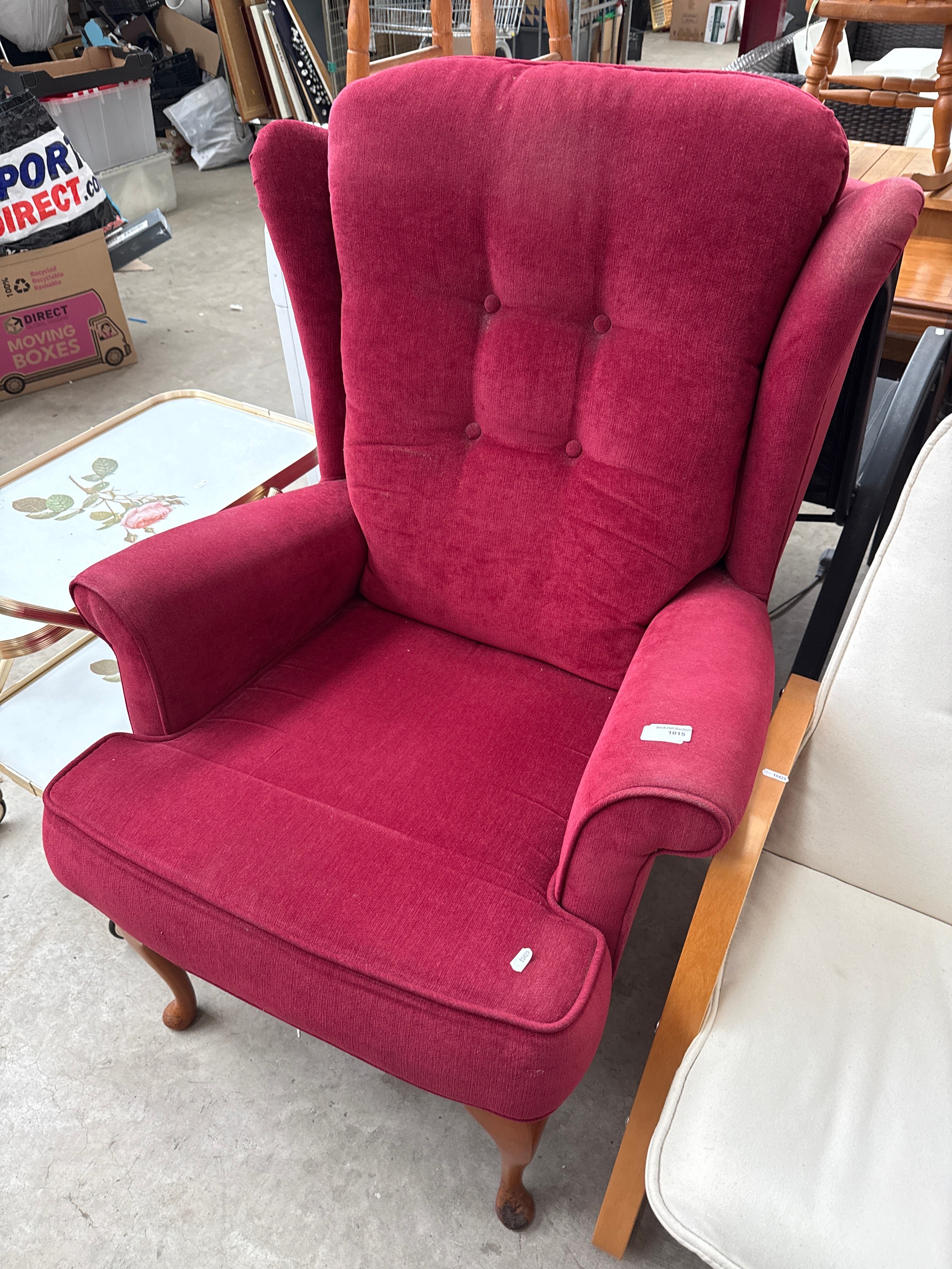 A vintage Queen Anne legged wing back armchair