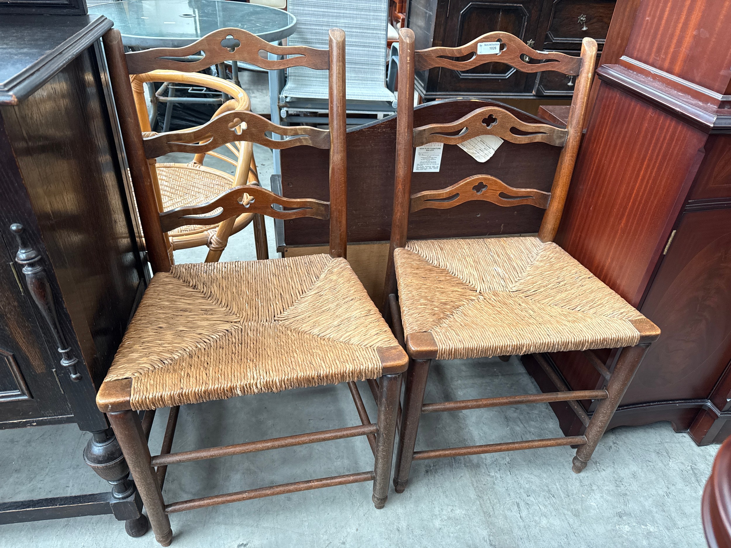 A pair of vintage rush seated ladder back chairs