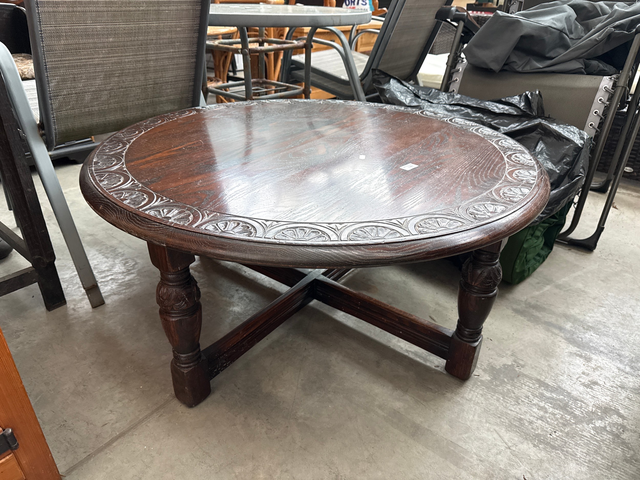 A large vintage circular carved coffee table on bulbous legged frame
