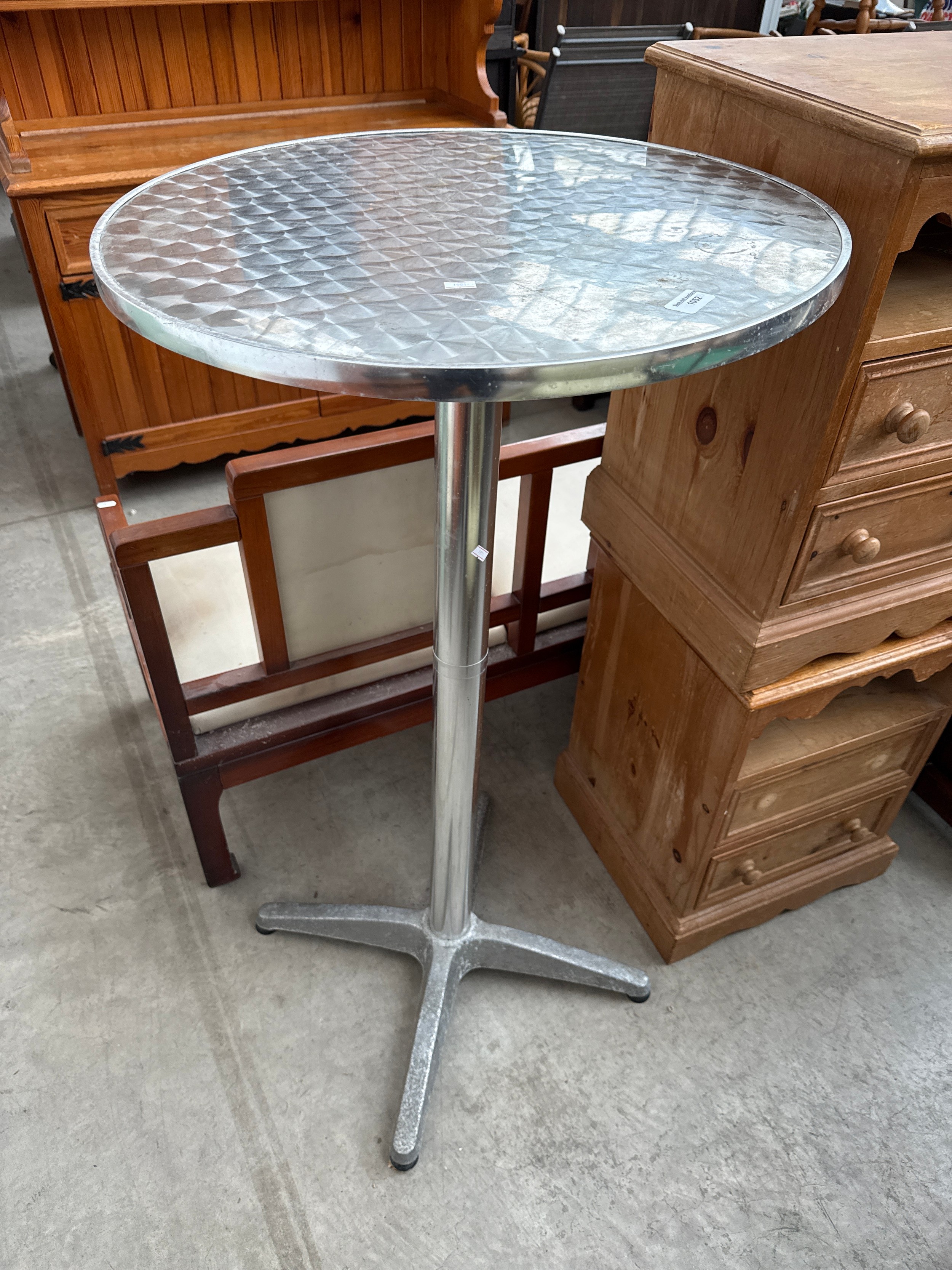 A tall stainless steel bistro bar table