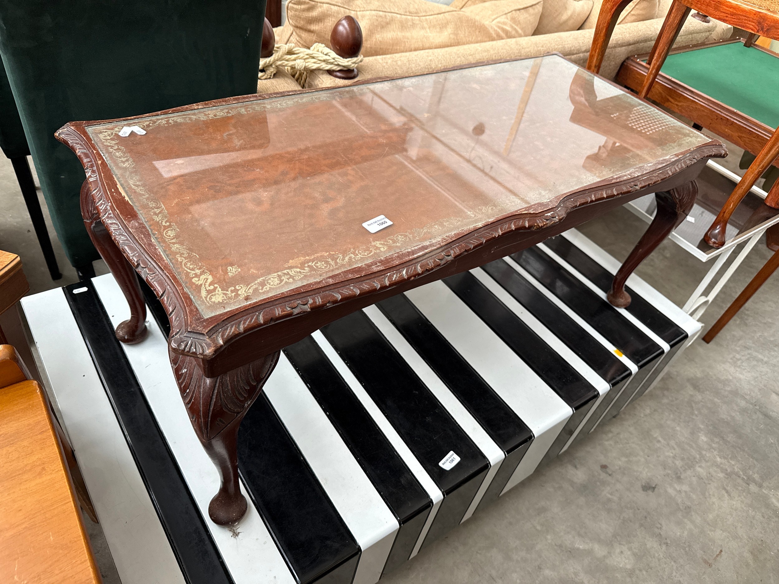 A vintage carved leather/glass topped coffee table