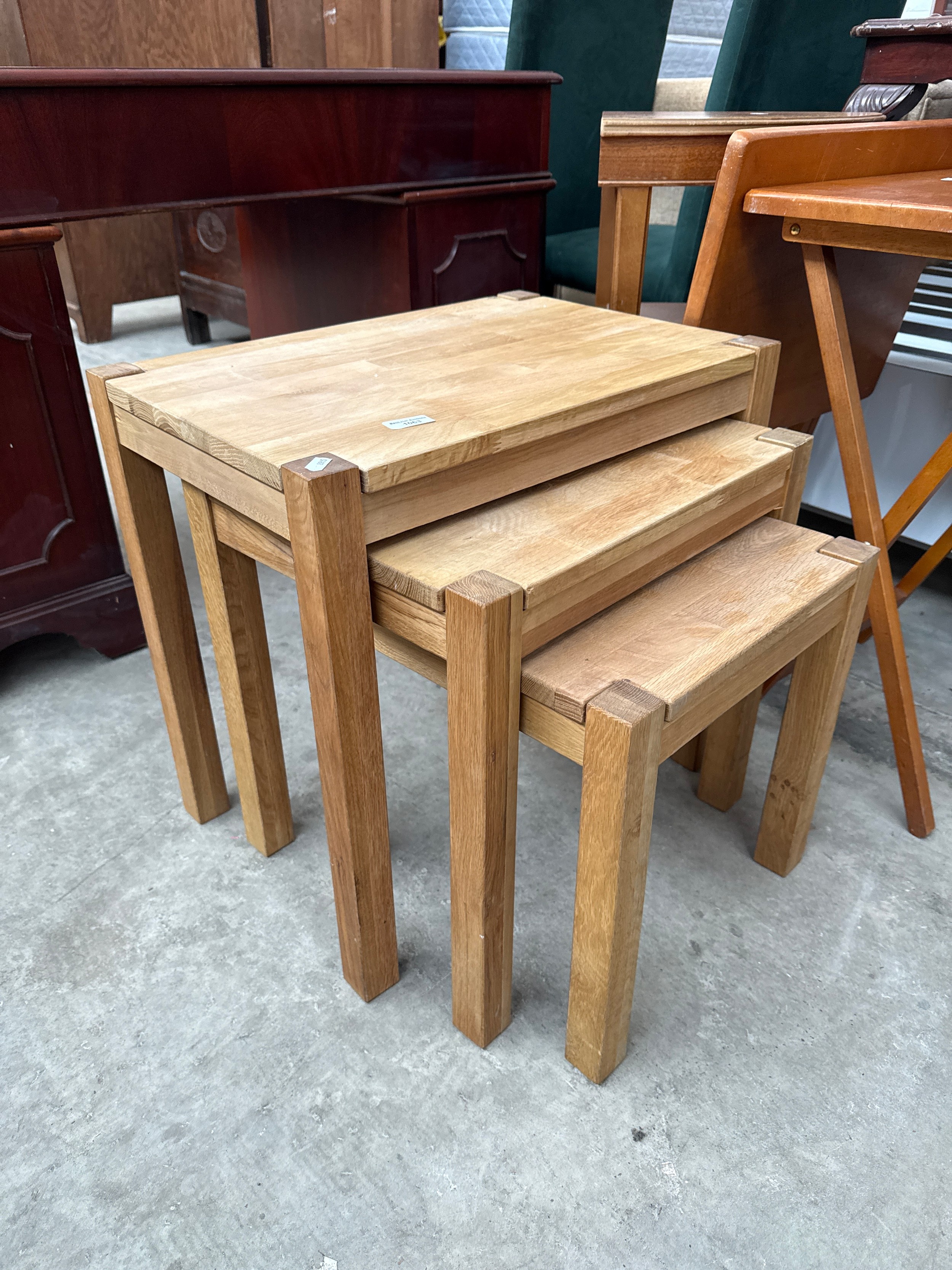 A nest of 3 x solid light oak occasional tables