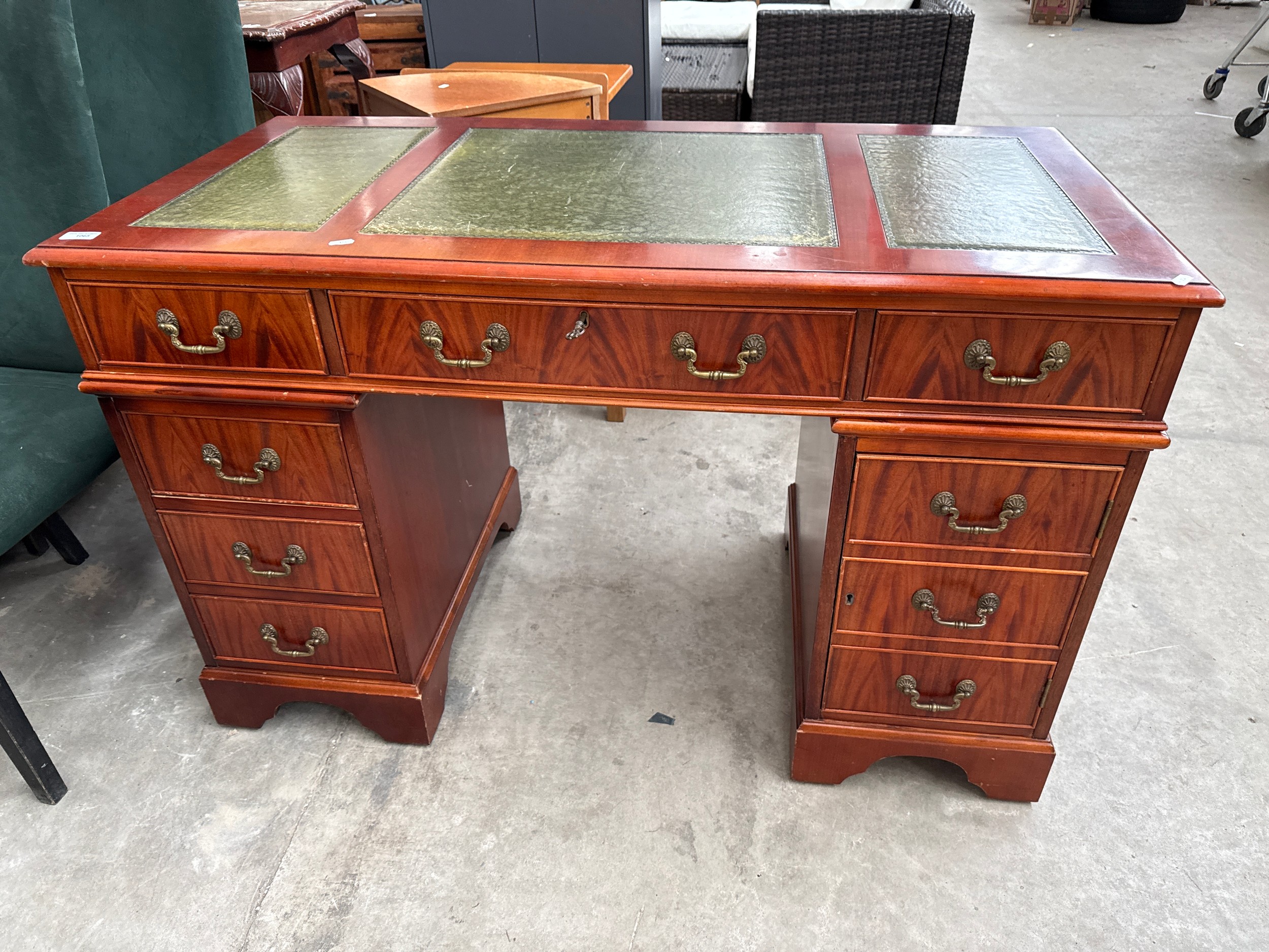 A vintage flame mahogany leather topped 6 drawer twin pedestal desk with side