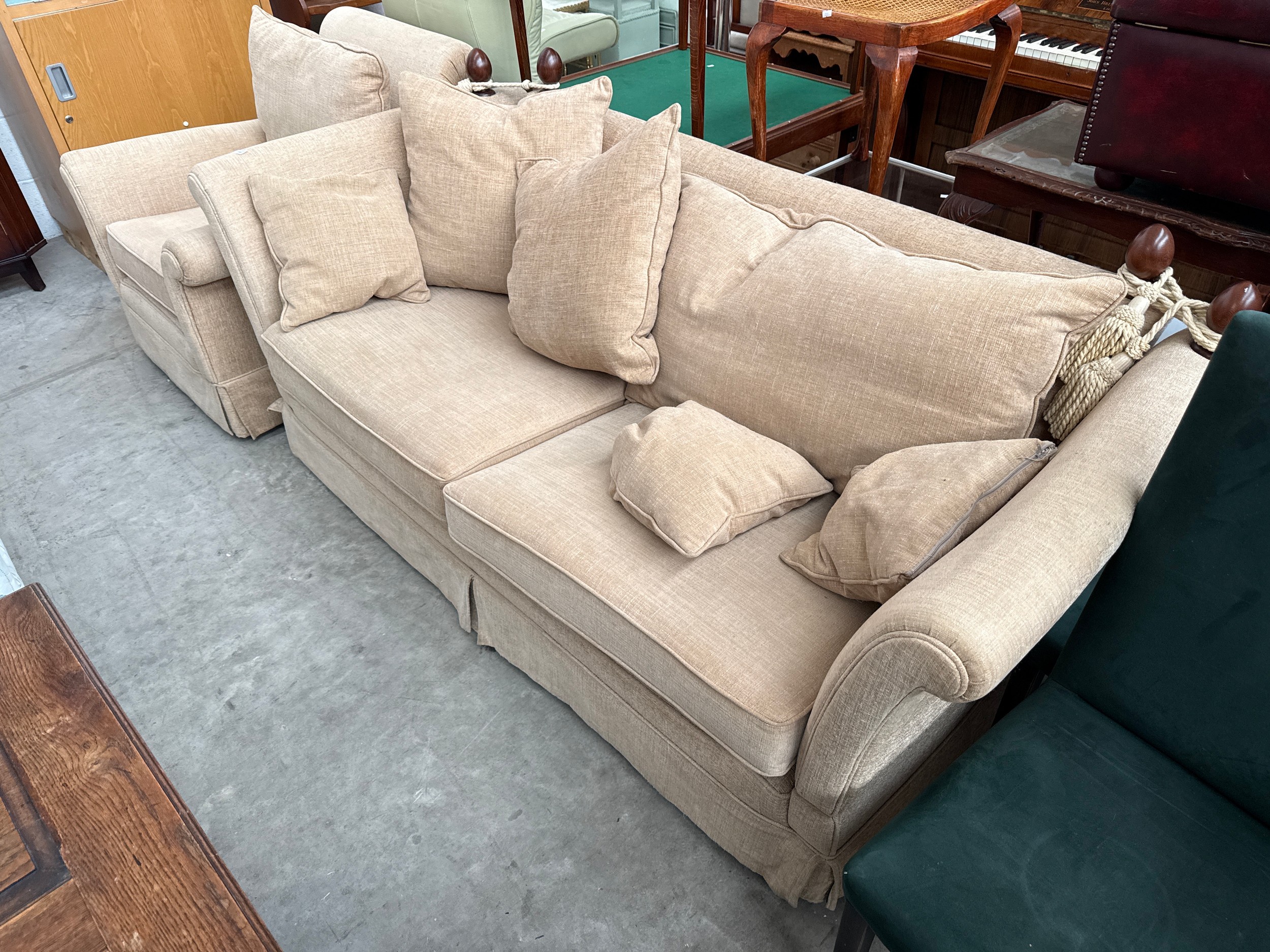 A large upholstered drop arm sofa with matching armchair and cushions