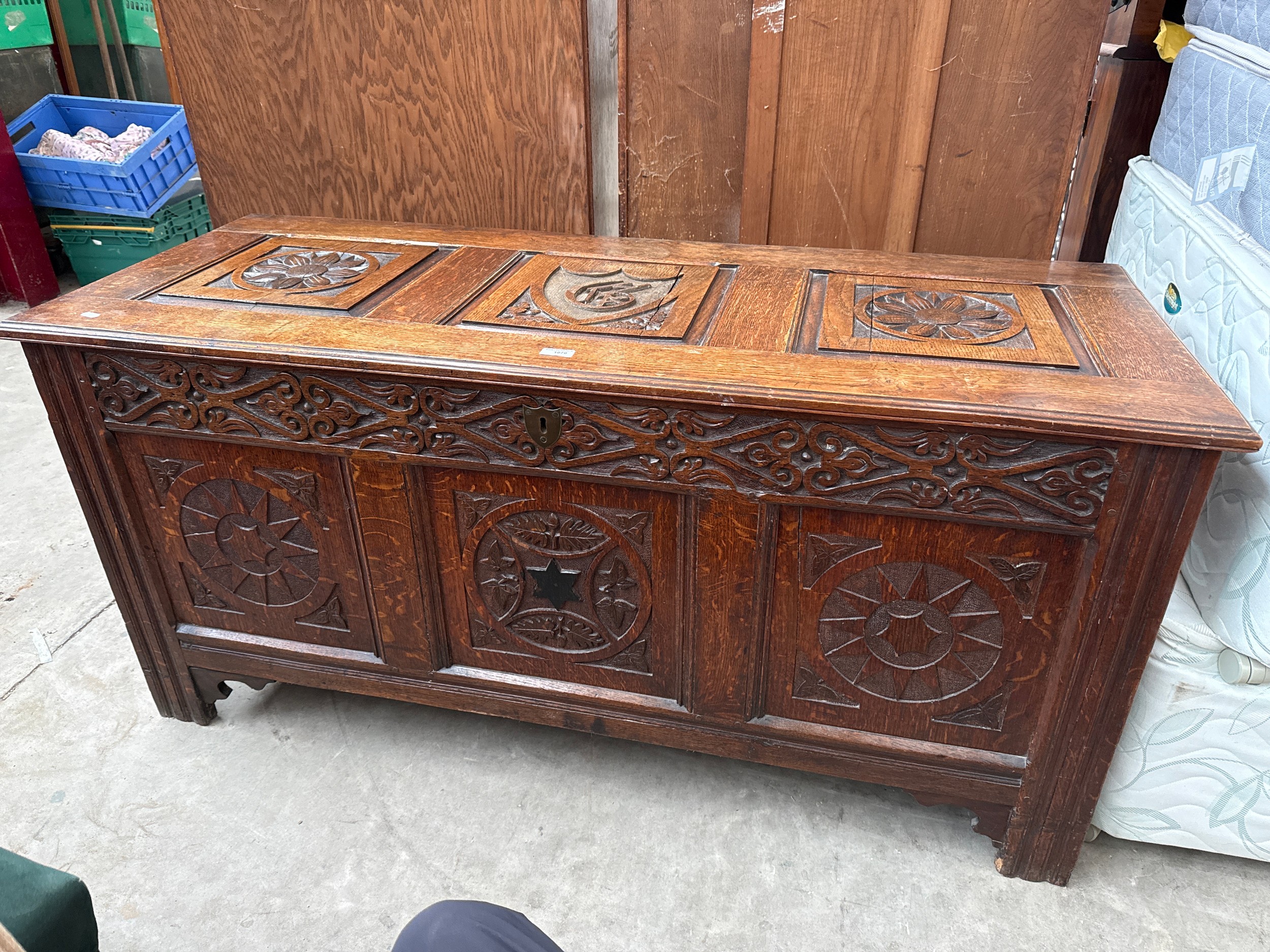 A large ornately carved antique lift top coffer
