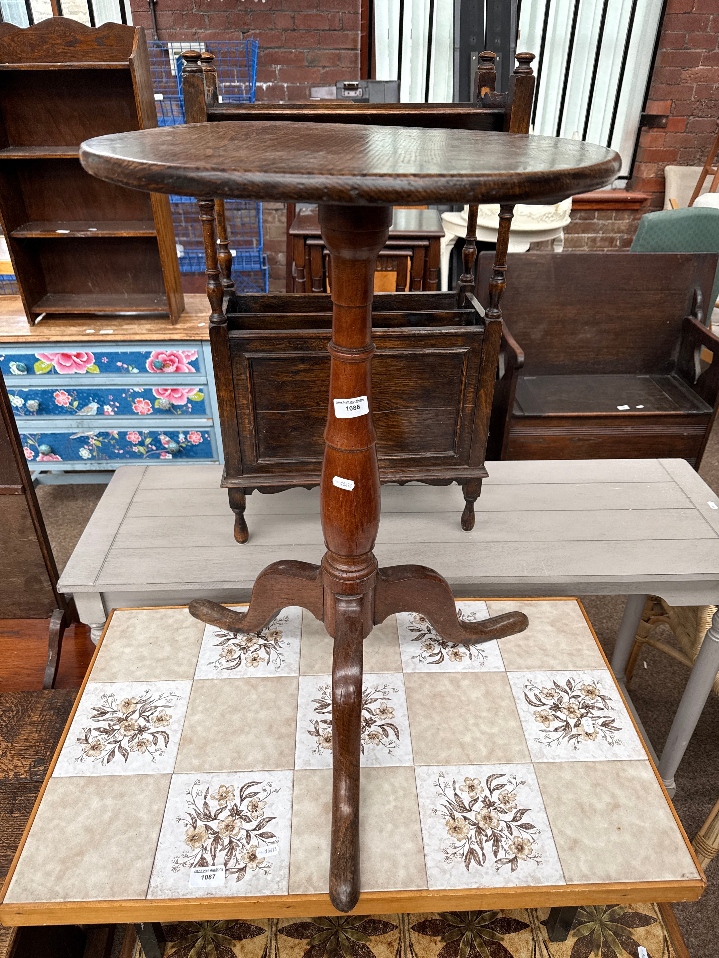A tall antique tripod table
