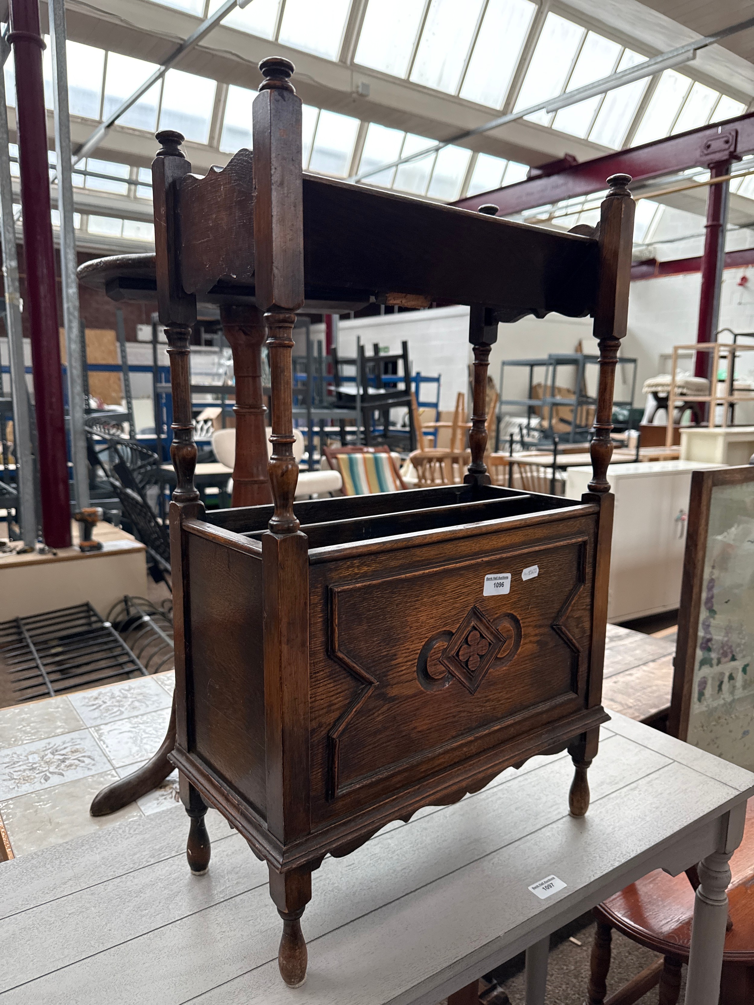 A vintage oak Jacobean style magazine rack with upper book trough
