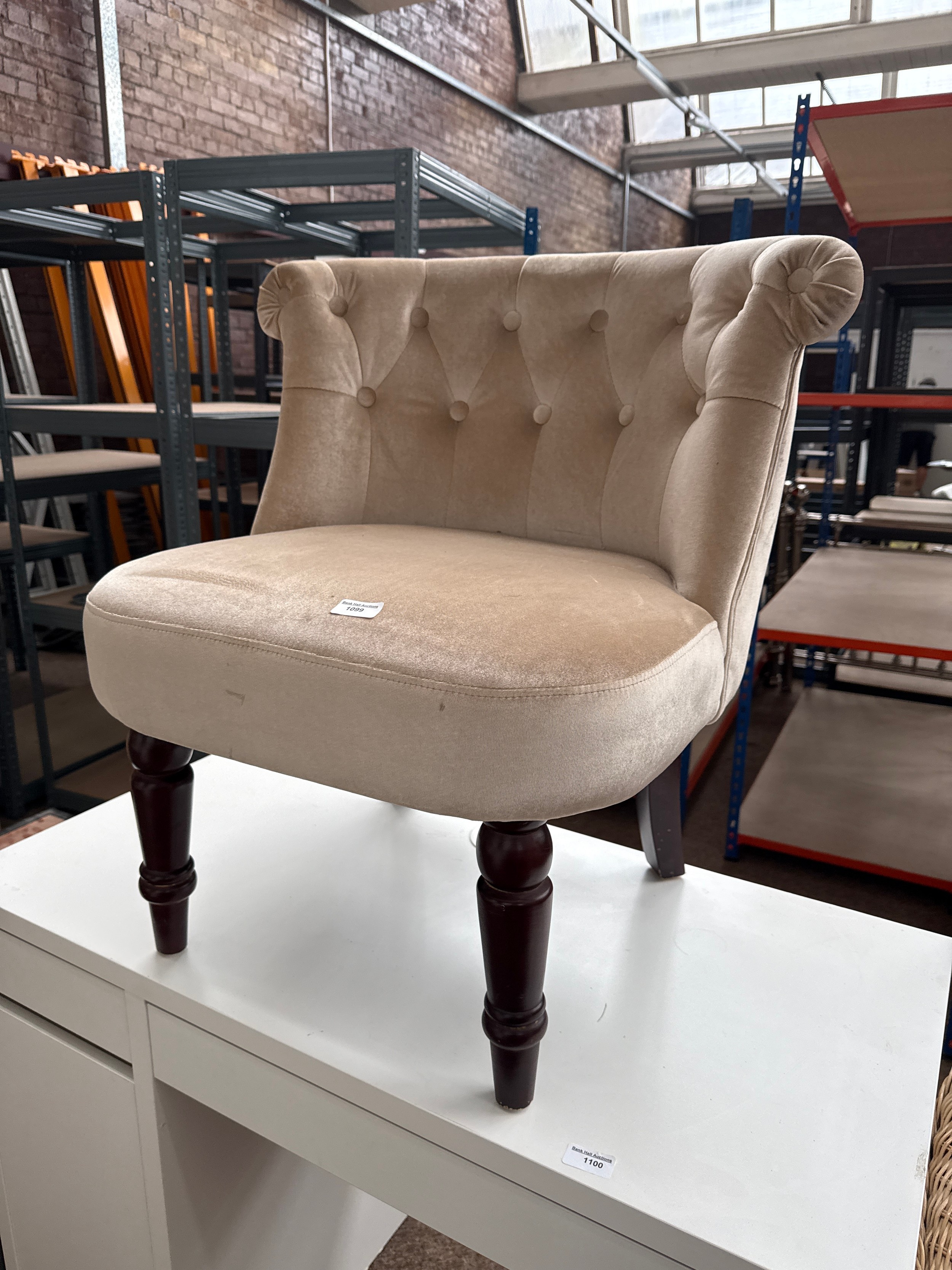 An upholstered button backed bedroom tub chair