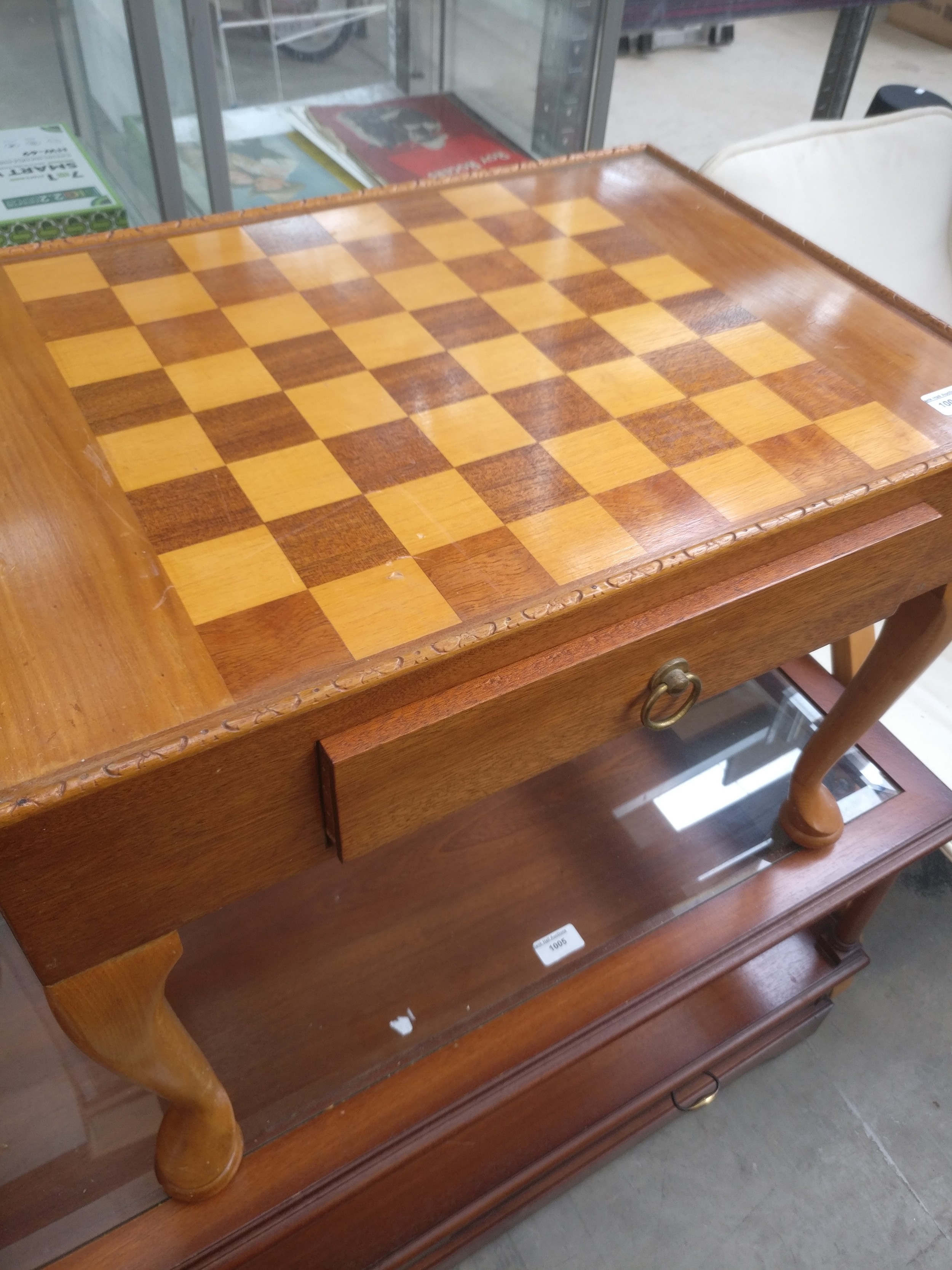 A small vintage coffee table with chess board top and side drawer