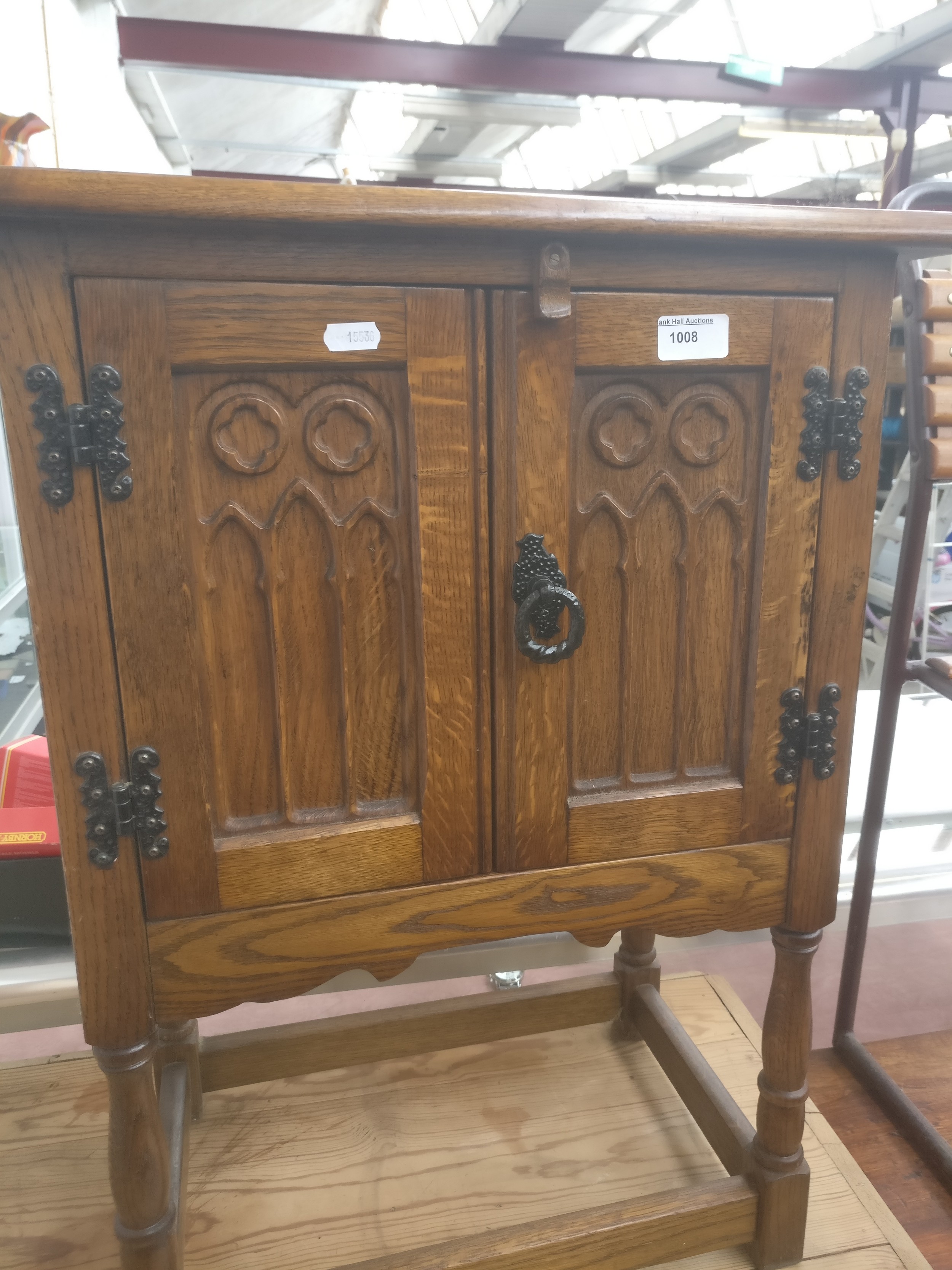 A small vintage 2 door oak cabinet with carved panels