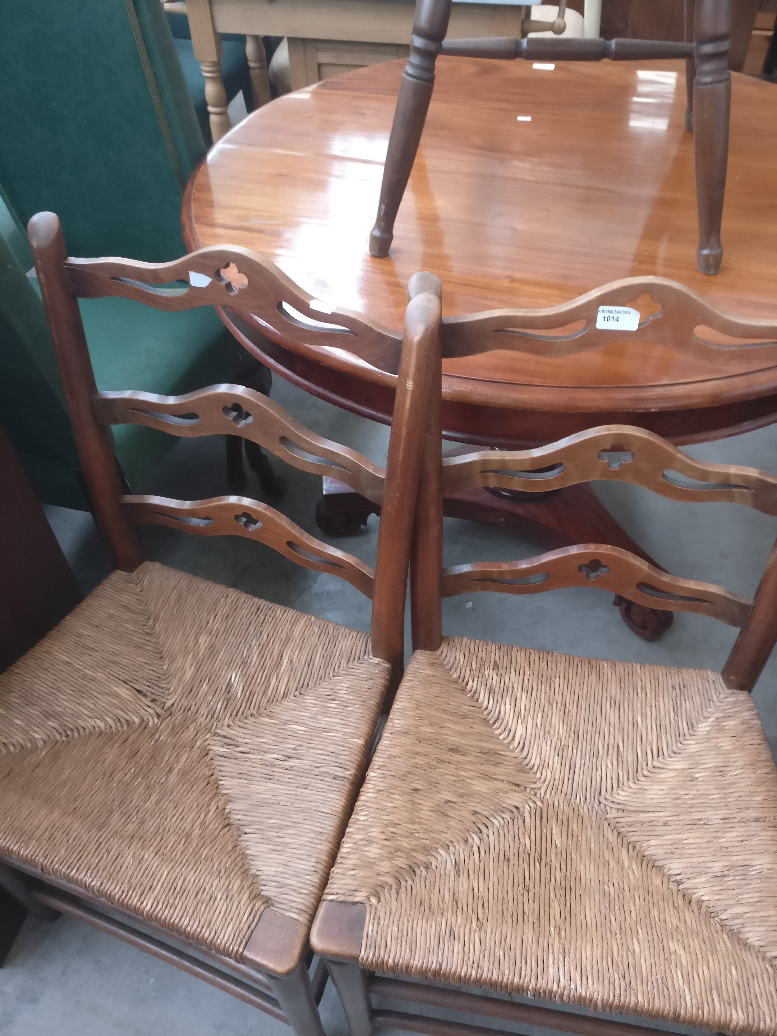 A pair of vintage rush seated ladder back dining chairs